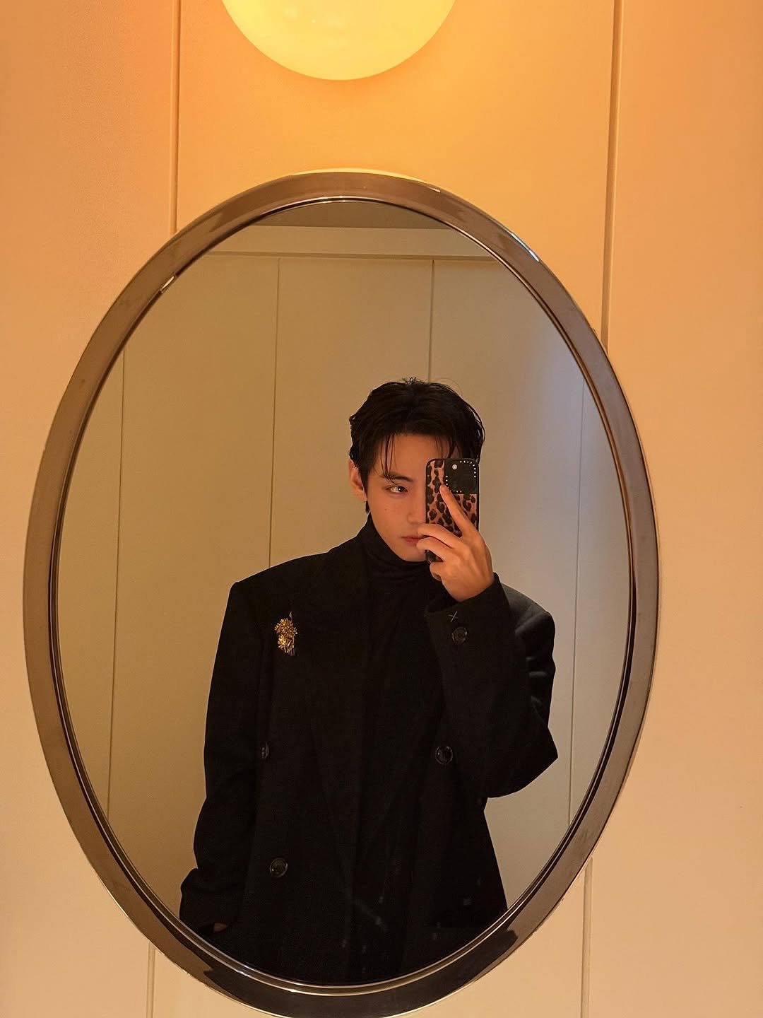 Photo by V on October 07, 2025. May be an image of 1 person, overcoat, duffle coat, mirror, bolo tie, blazer, suit, dinner jacket and text.