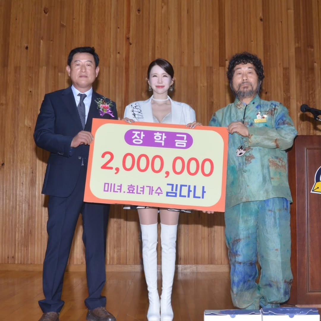 Photo by 김다나 on August 09, 2025. 사람 3명 및 문구: '장학금 2,000,000 미녀.효녀가수 미녀.효녀가수김다나 미녀. 효녀가수 김다나'의 이미지일 수 있음.