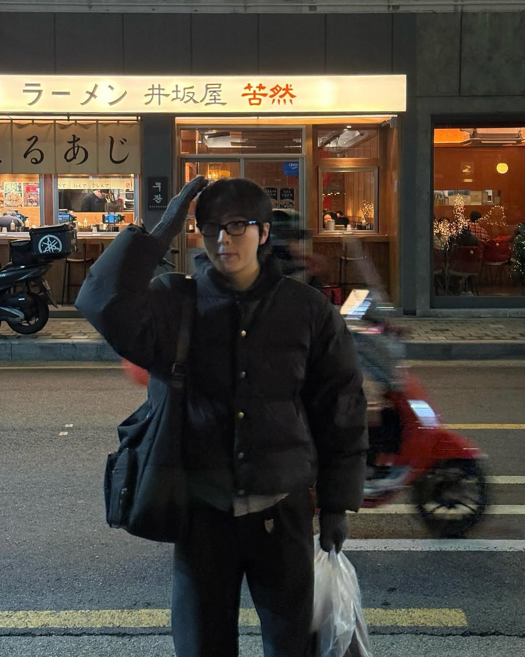 Photo shared by 정 한 on December 25, 2025 tagging @anotheroffice_official. May be an image of one or more people, duffle coat, parka, street and text that says 'ラーメン井坂屋告然 ラーメン 井坂屋 苦然'.