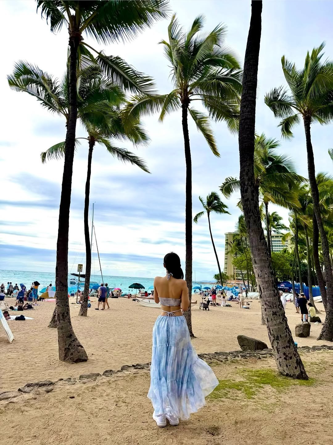 Photo by KISS OF LIFE on February 18, 2026. May be an image of sundress, parasol, sarong, palm trees and text.