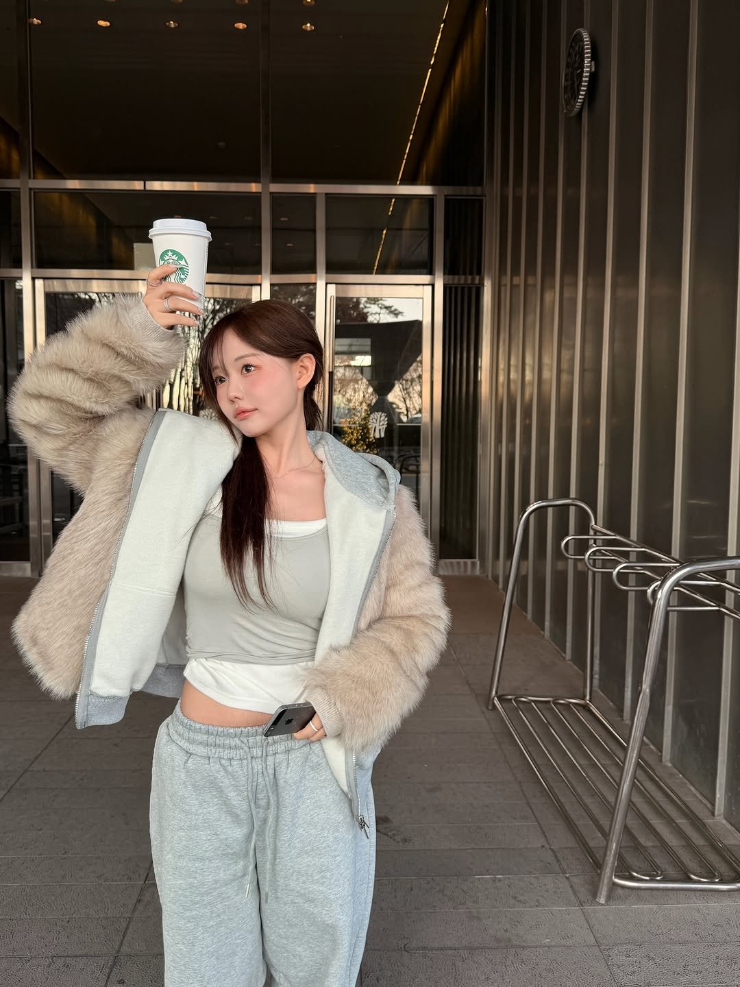 Photo shared by 홍영기 on December 14, 2025 tagging @kisyning. May be an image of phone, sweatpants, fur, sweatsuit, parka, coat, cornflower and text.