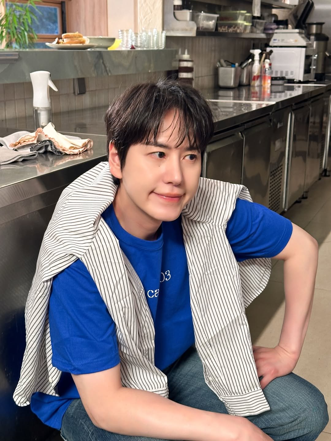 Photo shared by 규현 KYUHYUN on February 18, 2026 tagging @gyuram88. May be an image of one or more people, bangs, apron and text.