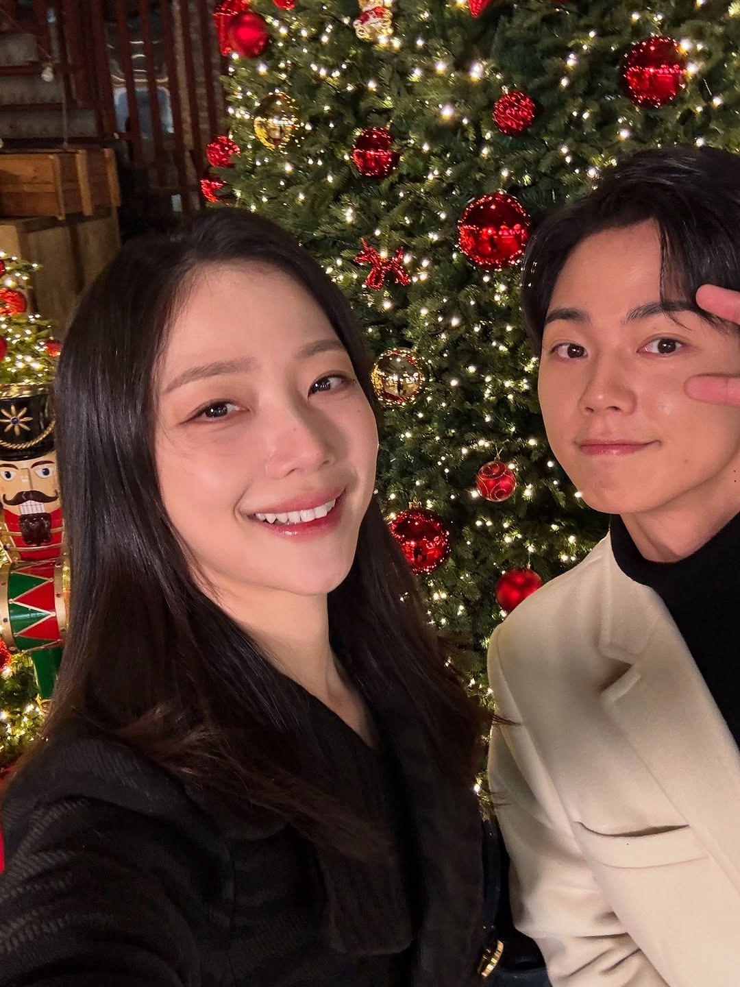 Photo by 김규선 KIM KYUSEON on December 23, 2025. May be a selfie of one or more people, christmas tree, duffle coat, tinsel and text.