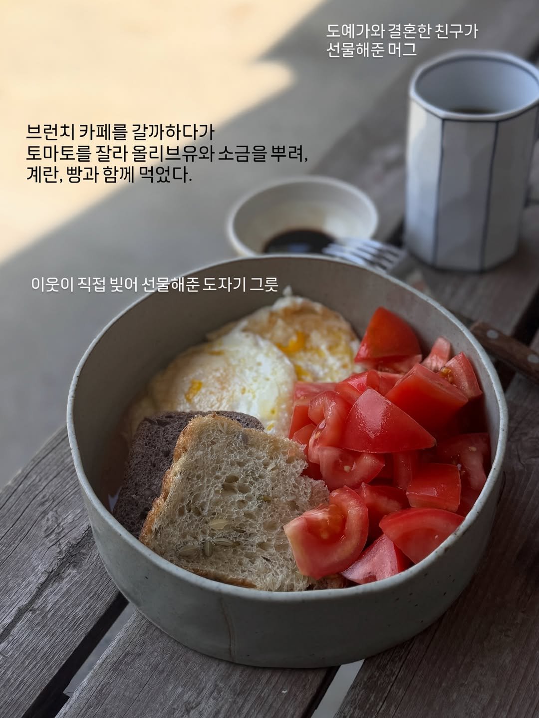 Photo by 레이지마마 리즈 on April 25, 2026. May be an image of tofu, bread, egg, kitchenware and text that says '도예가와 결혼한 친구가 선물해준머그 브런치카페를 브런치 카페를 갈까하다가 토마토를 토를 잘라 올리브유와 소금을 뿌려, 계란, 빵과 함께 먹었다. 이웃이 직접 빚어 선물해준도자기그릇 선물해준 그릇'.