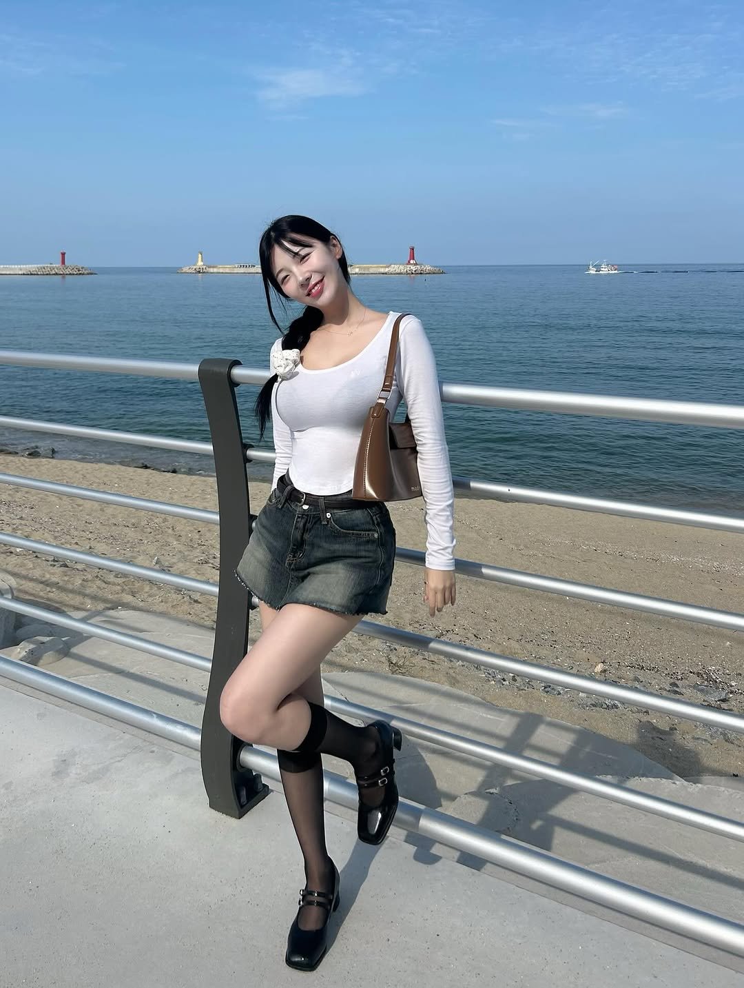 Photo by 쏘블리ღ🤍 on September 27, 2025. May be an image of 1 person, miniskirt, shorts, ocean and text.