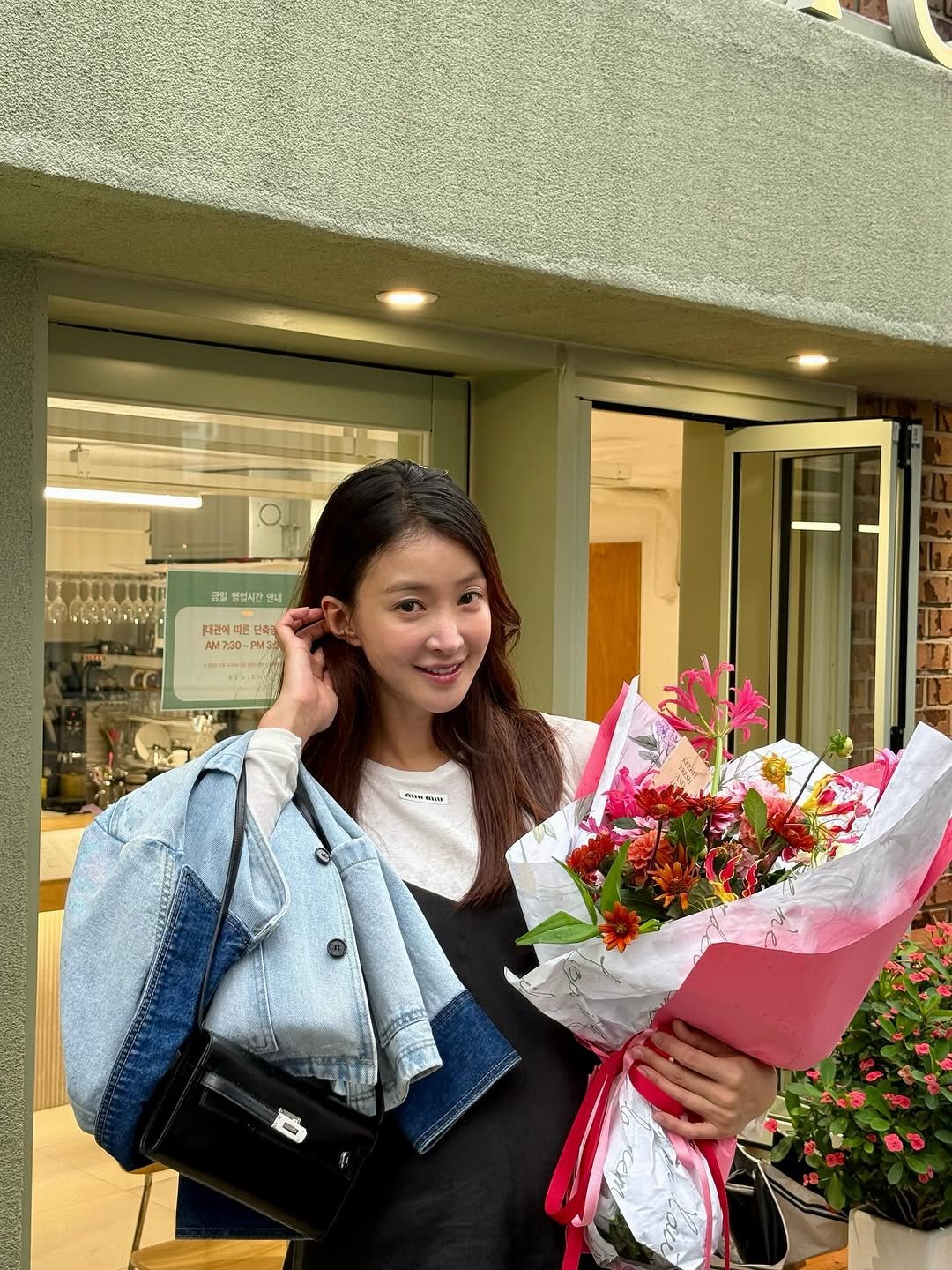 Photo by 이시영_Lee Si Young (actress)🇰🇷 on September 24, 2025. May be an image of 1 person, flower arrangement, bouquet, white lily, prairie gentian, baby's-breath, carnation, rose and text that says '군실 ስ 업시간 안내 대관에 퍼른단 단피한 AM7:30-P 7:30-P M33 ま画'.