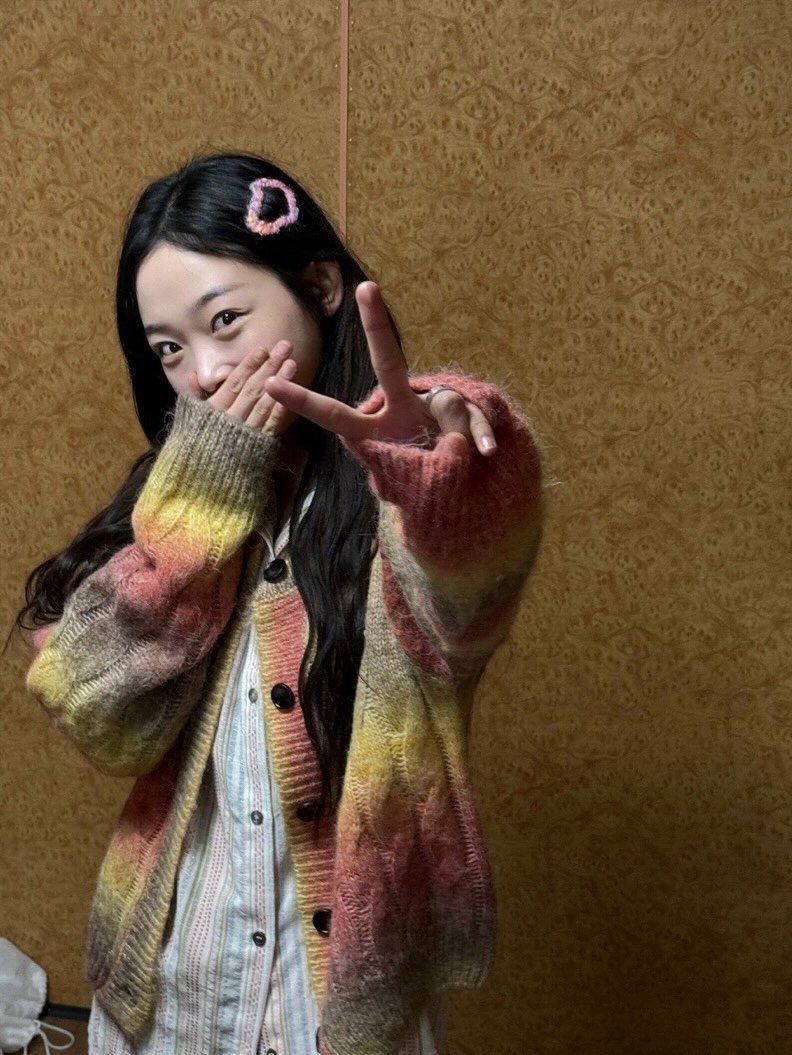 Photo by 이유미 on November 26, 2025. May be an image of one or more people, braids, duffle coat, sweater, knit, cardigan and text.