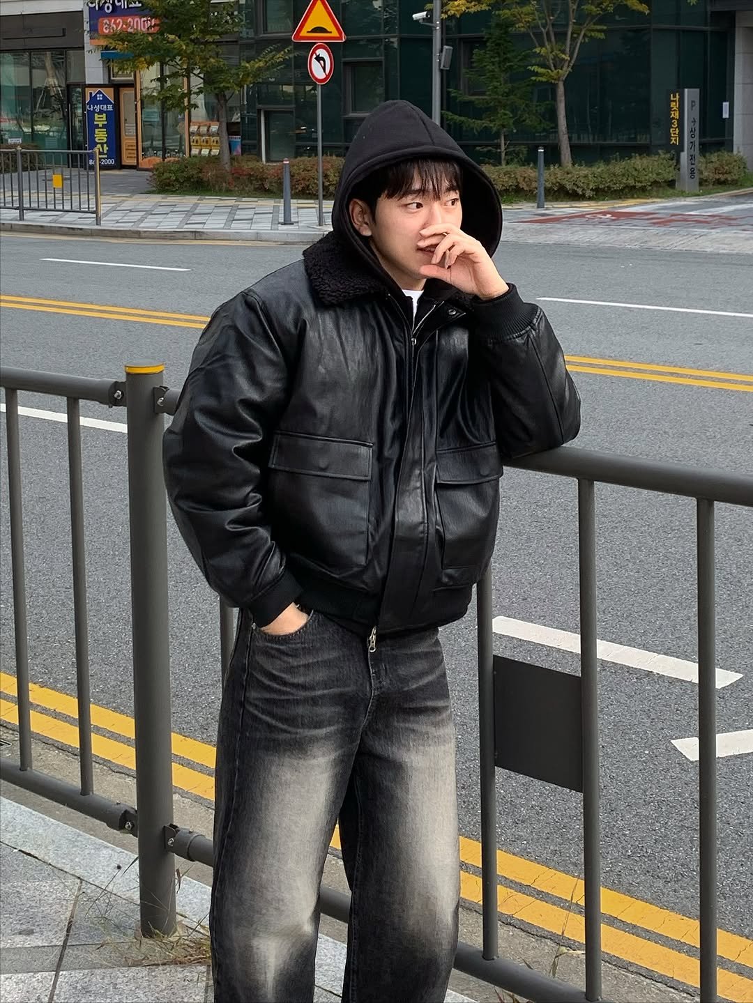 Photo by 르니던 on November 25, 2025. May be an image of one or more people, duffle coat, parka, cigarette, street and text.