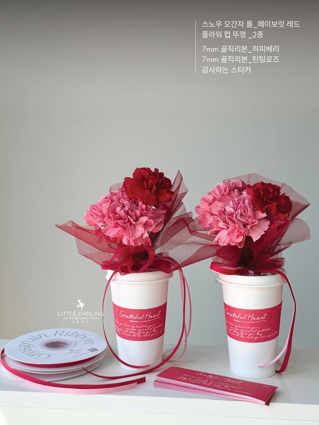 Photo by (주)리틀달링✨ 꽃자재, 패키지디자인 on April 23, 2026. May be an image of ‎coffee cup, hamper, flower arrangement, prairie gentian, baby's-breath, carnation, rose and ‎text that says '‎스노우 오간자 롤. _페이보릿 레드 플라워 컵 뚜껑 _2종 7mm 골직리본 히피베리 7mm 골직리본_틴팅로즈 _틴팅로즈 감사하는 감사하는스티커 스티커 LITTLF LITTLEDARLING DARLING CNE Gratcful GratehulHeart HK ان p Ribe لوار K6 EntefulHeant sateful Heant.‎'‎‎.