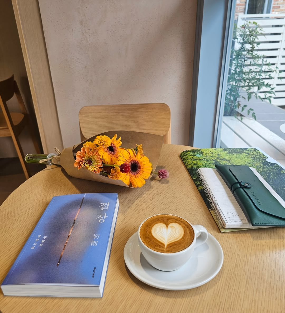 Photo by 작은코도마뱀 on September 24, 2025. May be an image of coffee cup, coffee, diary, cappuccino, book, cornflower, baby's-breath and text.