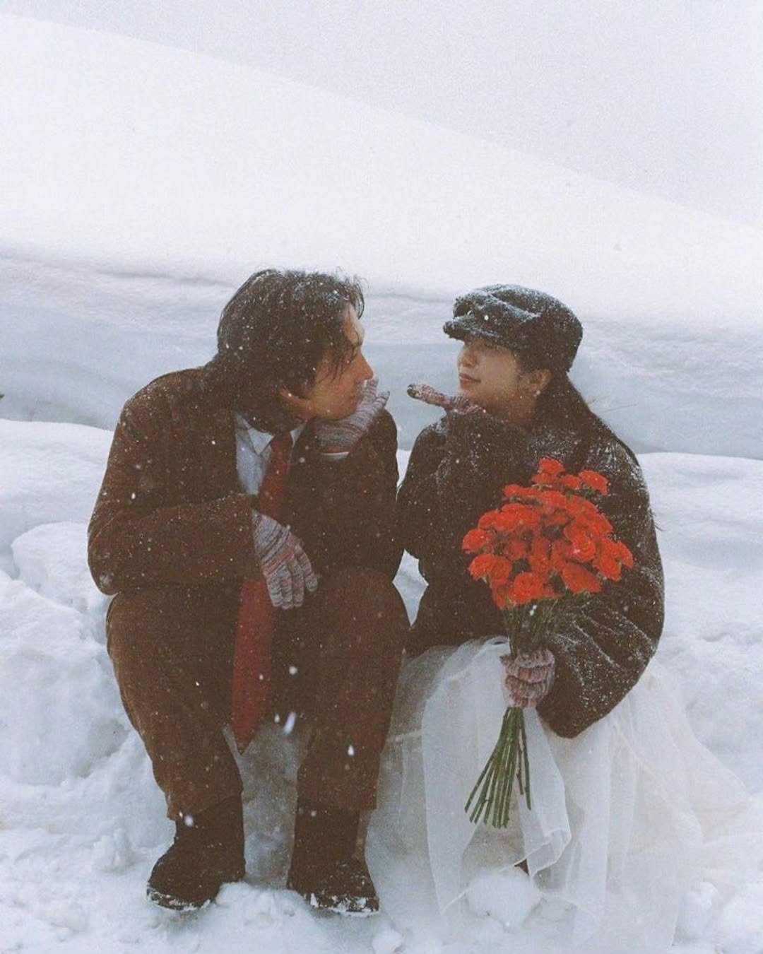 Photo by 임우연 on December 03, 2025. May be an image of people kissing, snowball, wedding, snow and text.