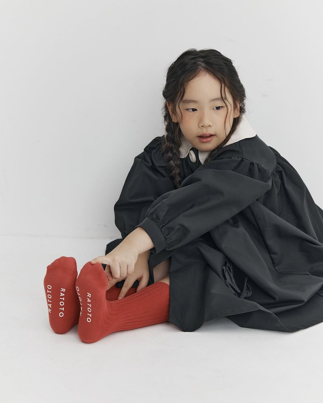 Photo by RATOTO/자체제작 on October 27, 2025. May be an image of braids, baby, duffle coat, dress, cloak, boots and text.