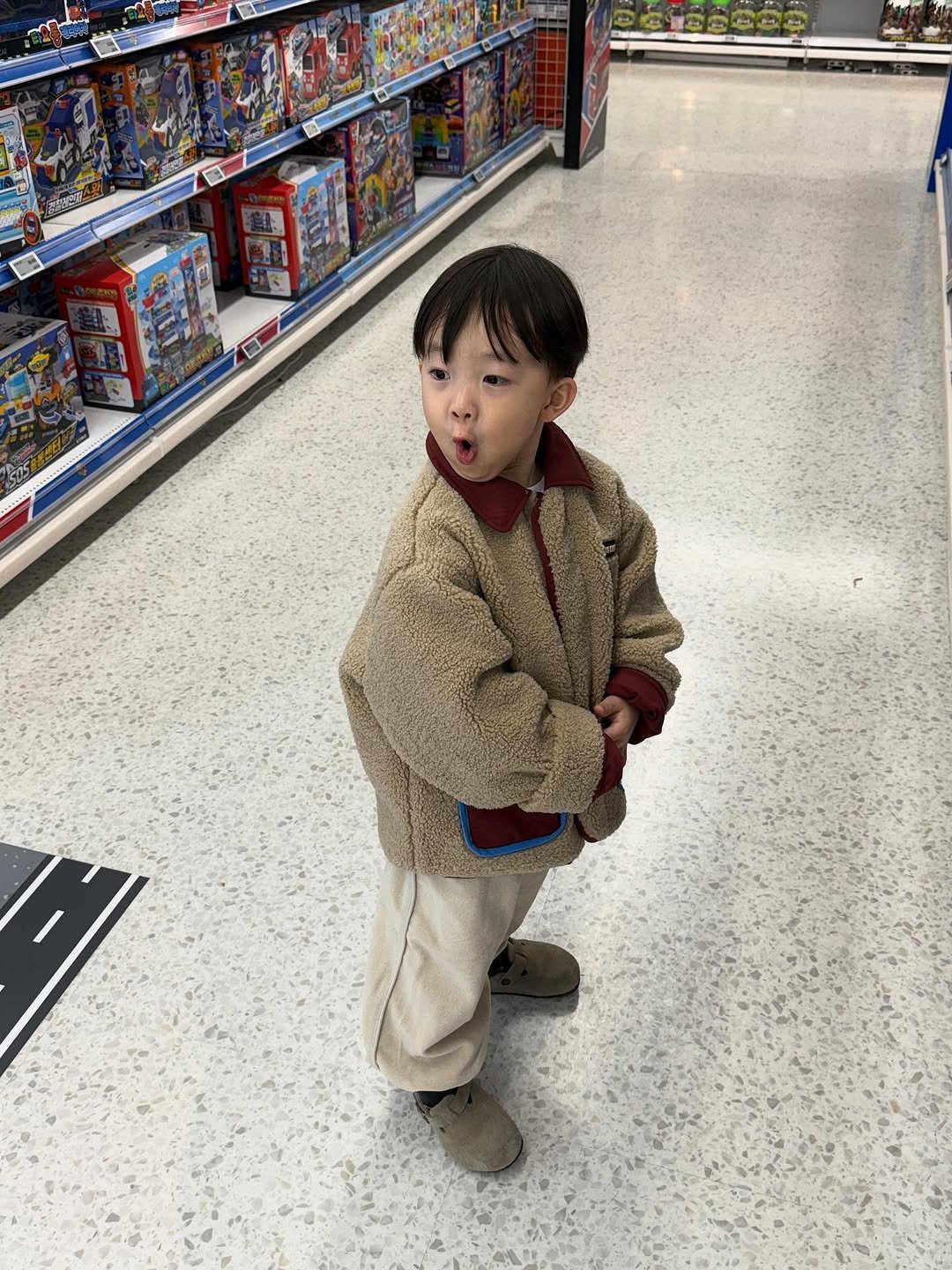 Photo by 이윤아 (태요미네) on November 10, 2025. May be an image of baby, duffle coat, bath robe, shopping cart and text.