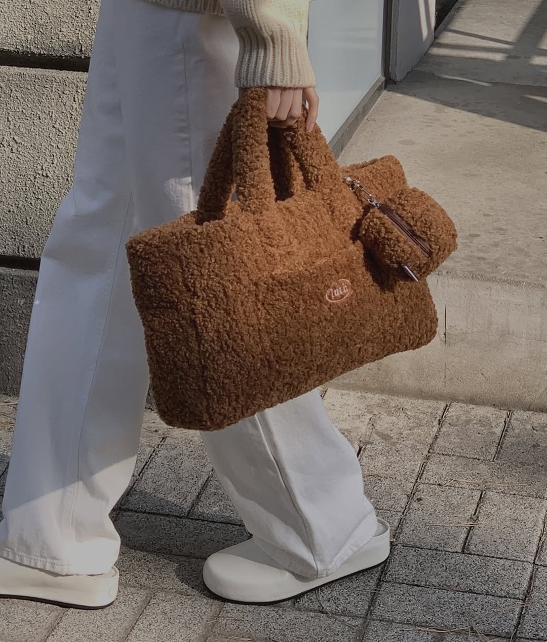 Photo by LUTH on December 05, 2025. May be an image of purse, drawstring, fur and text.