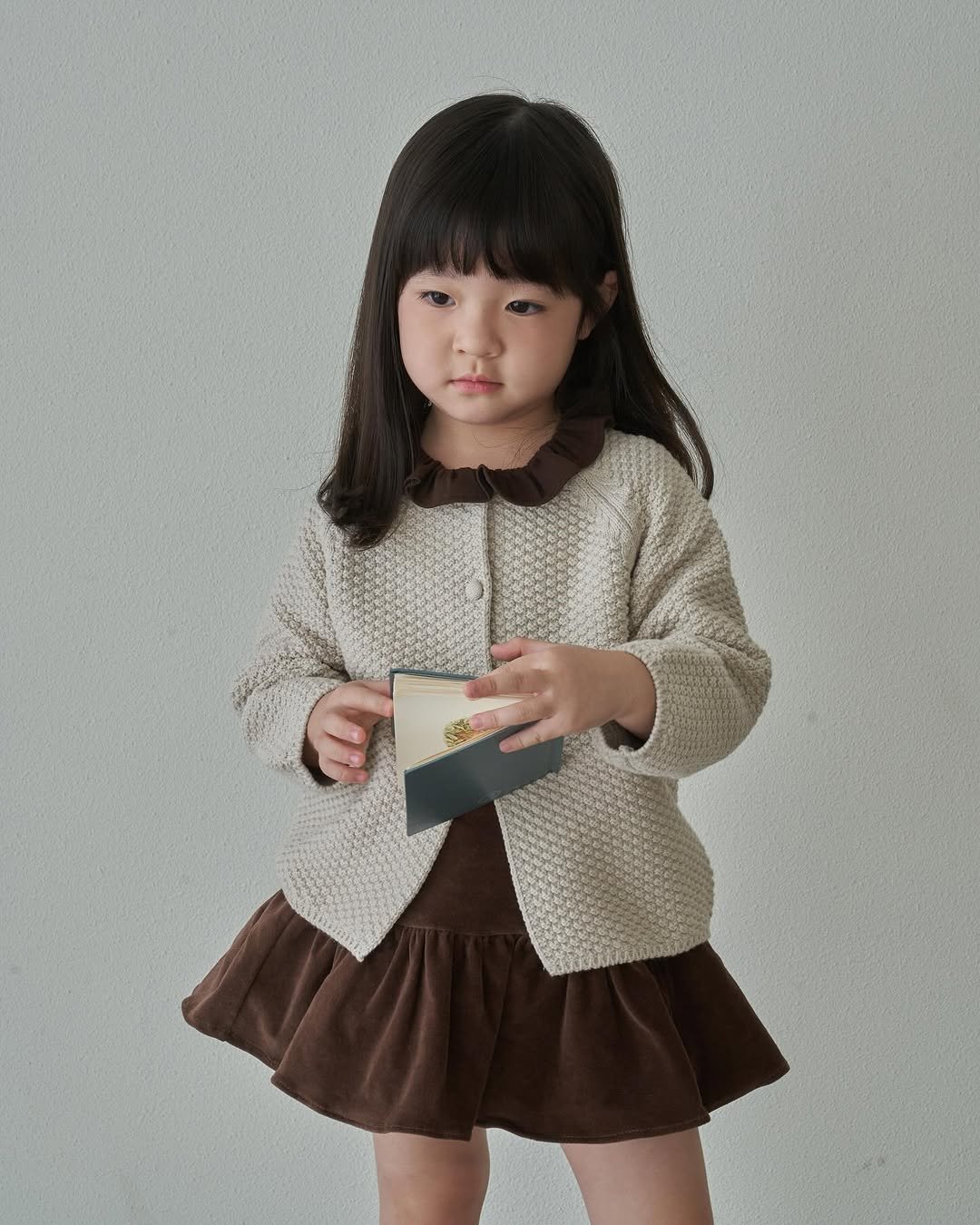 Photo by 마망블랑 mamanblanc on September 07, 2025. May be an image of 1 person, child, duffle coat, cardigan, knit and text.