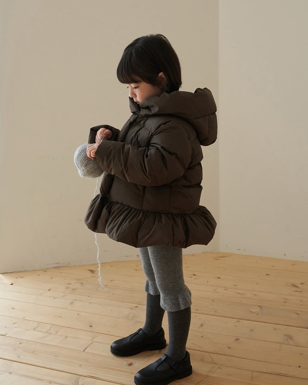 Photo by 마망블랑 mamanblanc on November 09, 2025. May be an image of child, duffle coat, goosedown coat, parka, boots and text.