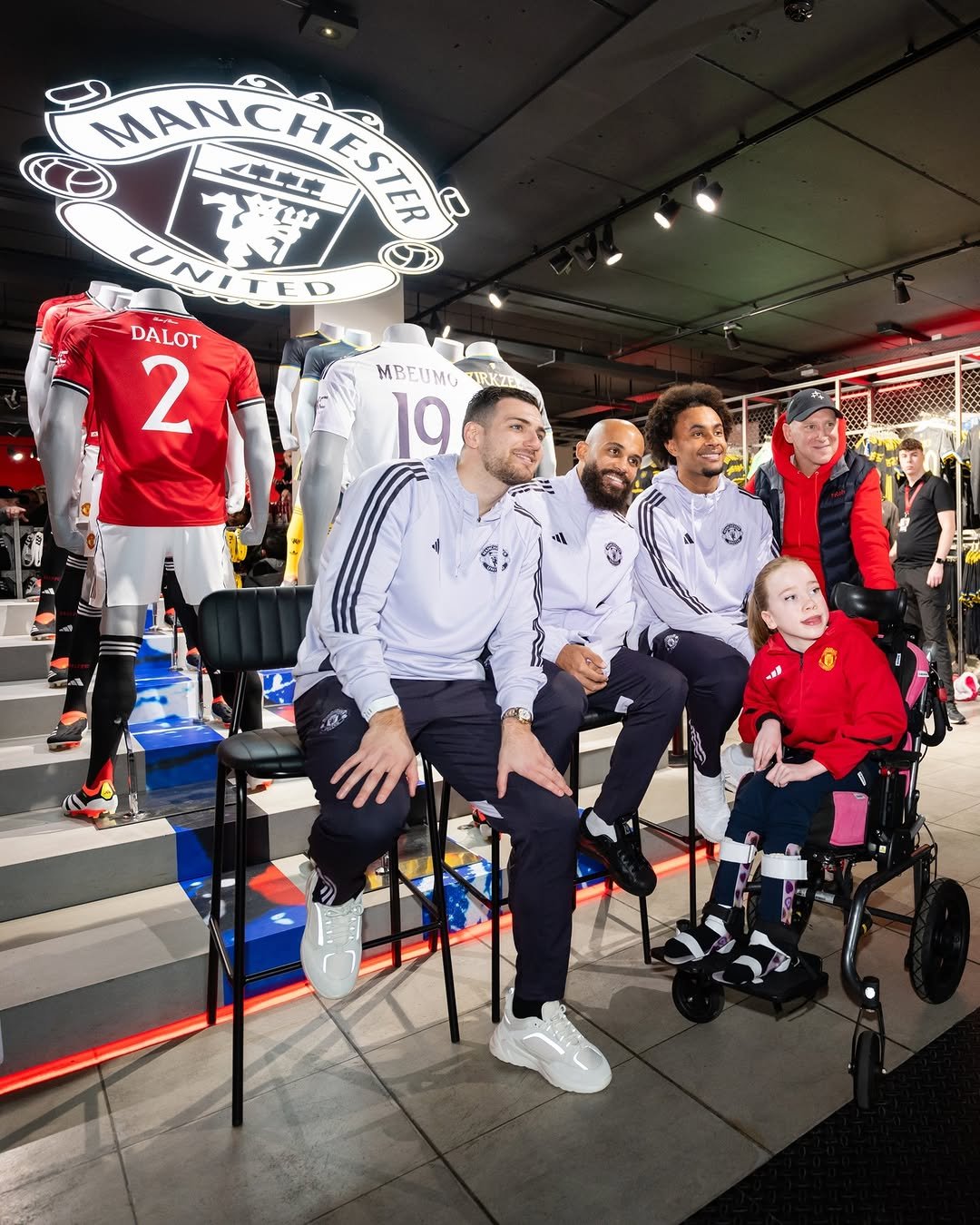 Diogo Dalot, Bryan Mbeumo and Joshua Zirkzee with a Manchester United fan.