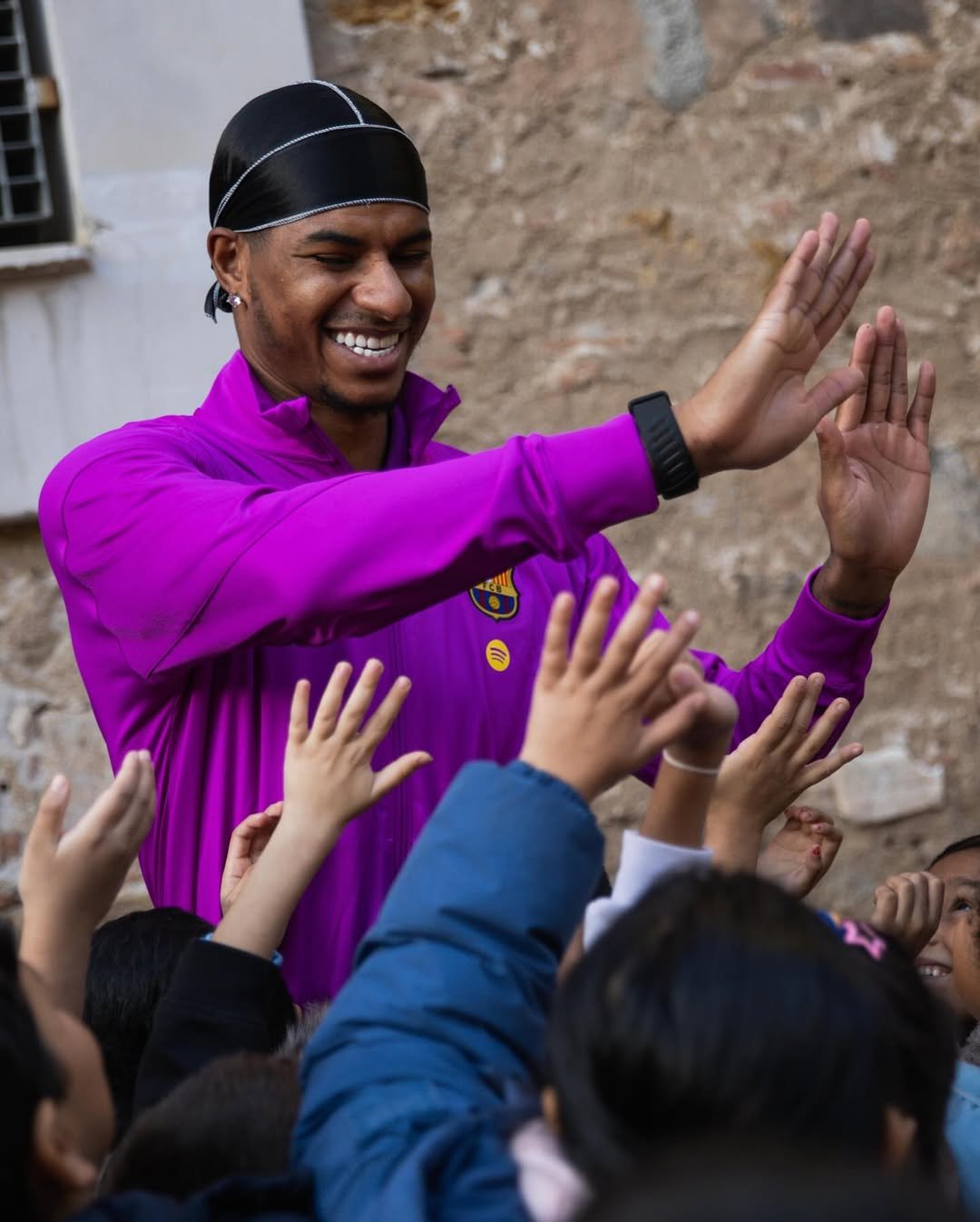 Photo shared by MR14 on December 11, 2025 tagging @fcbarcelona, and @fundaciofcb. May be an image of child, headscarf, head covering, crowd and text.