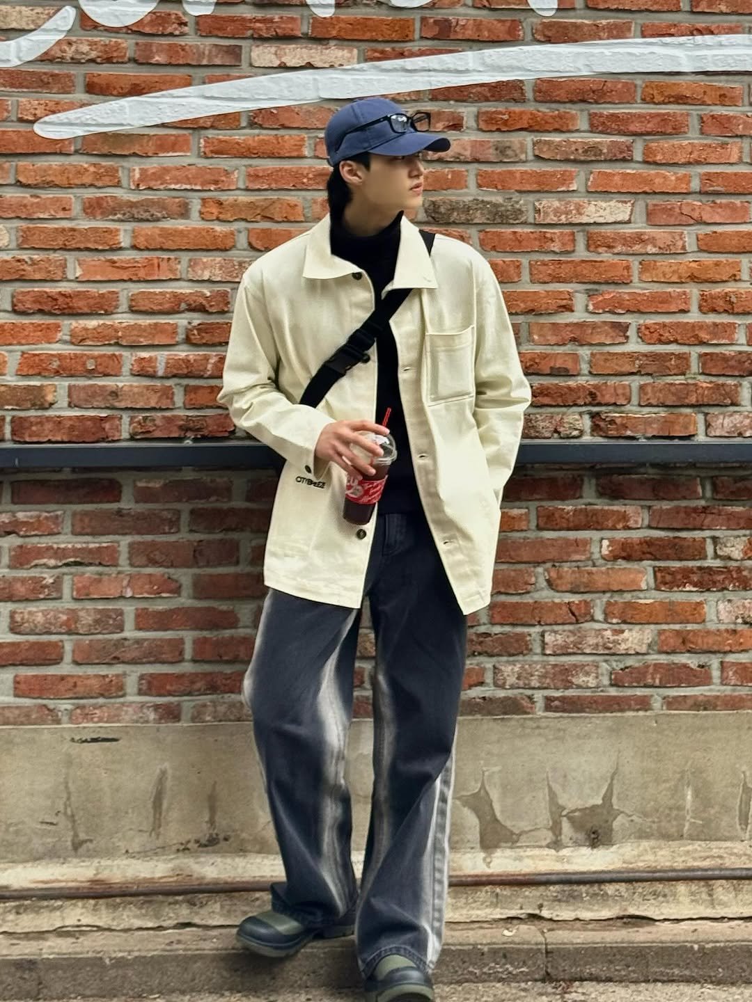 Photo by 주윤찬 on March 31, 2026. May be an image of duffle coat, overcoat, hat, wingtip shoes, parka, brick wall and text.