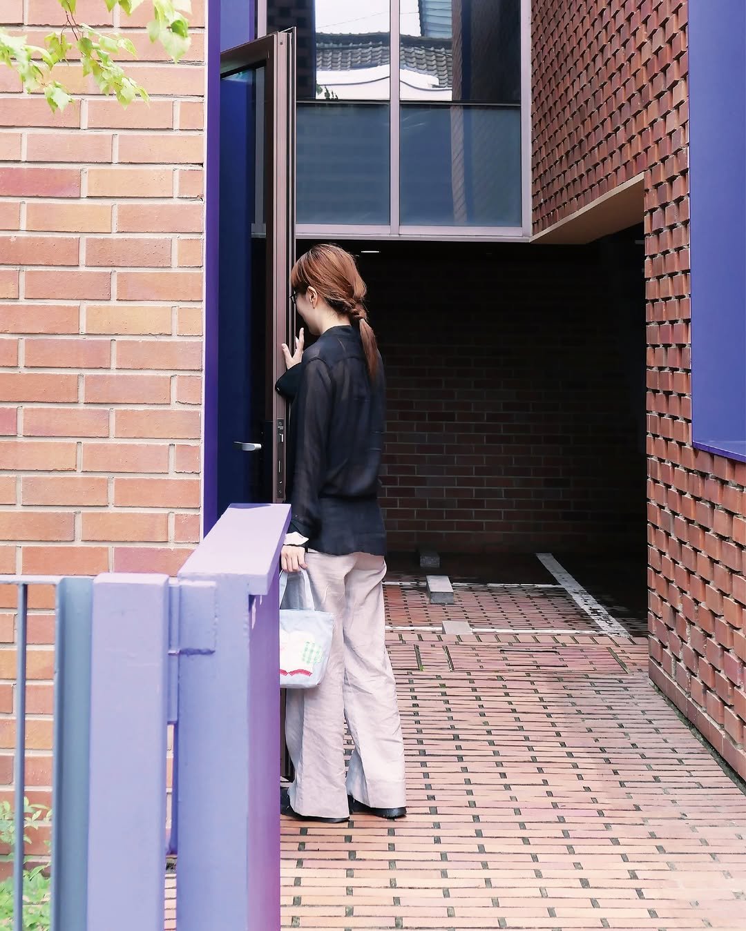 Photo by 마음산책 on September 24, 2025. May be an image of 1 person, hallway, brick wall, buildings, door, window and text.