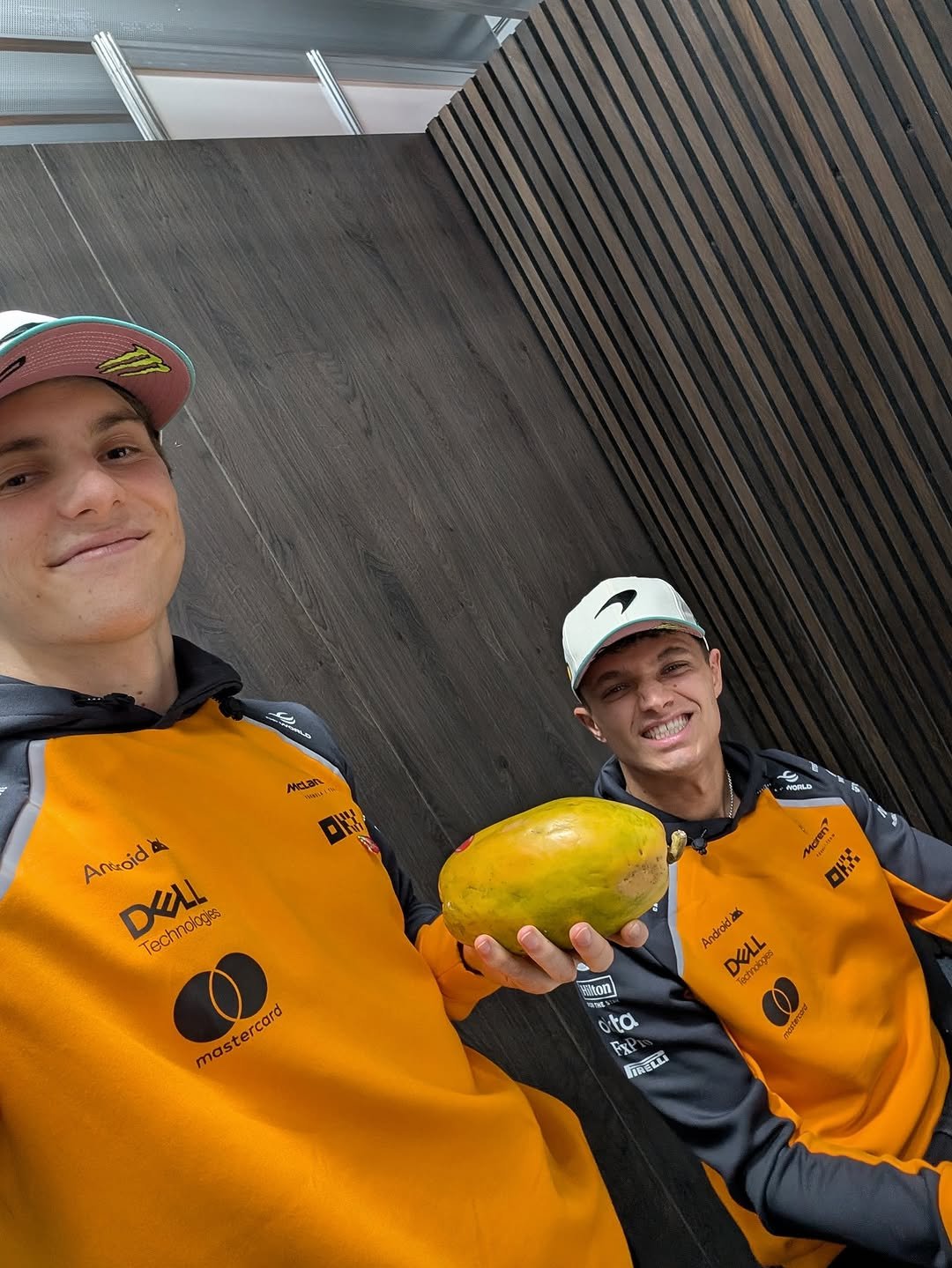 Photo by McLaren in São Paulo, Brazil with @lando, and @oscarpiastri. May be an image of hat, watermelon, mango, melon, papaya, cantaloupe, helmet, gourd and text.
