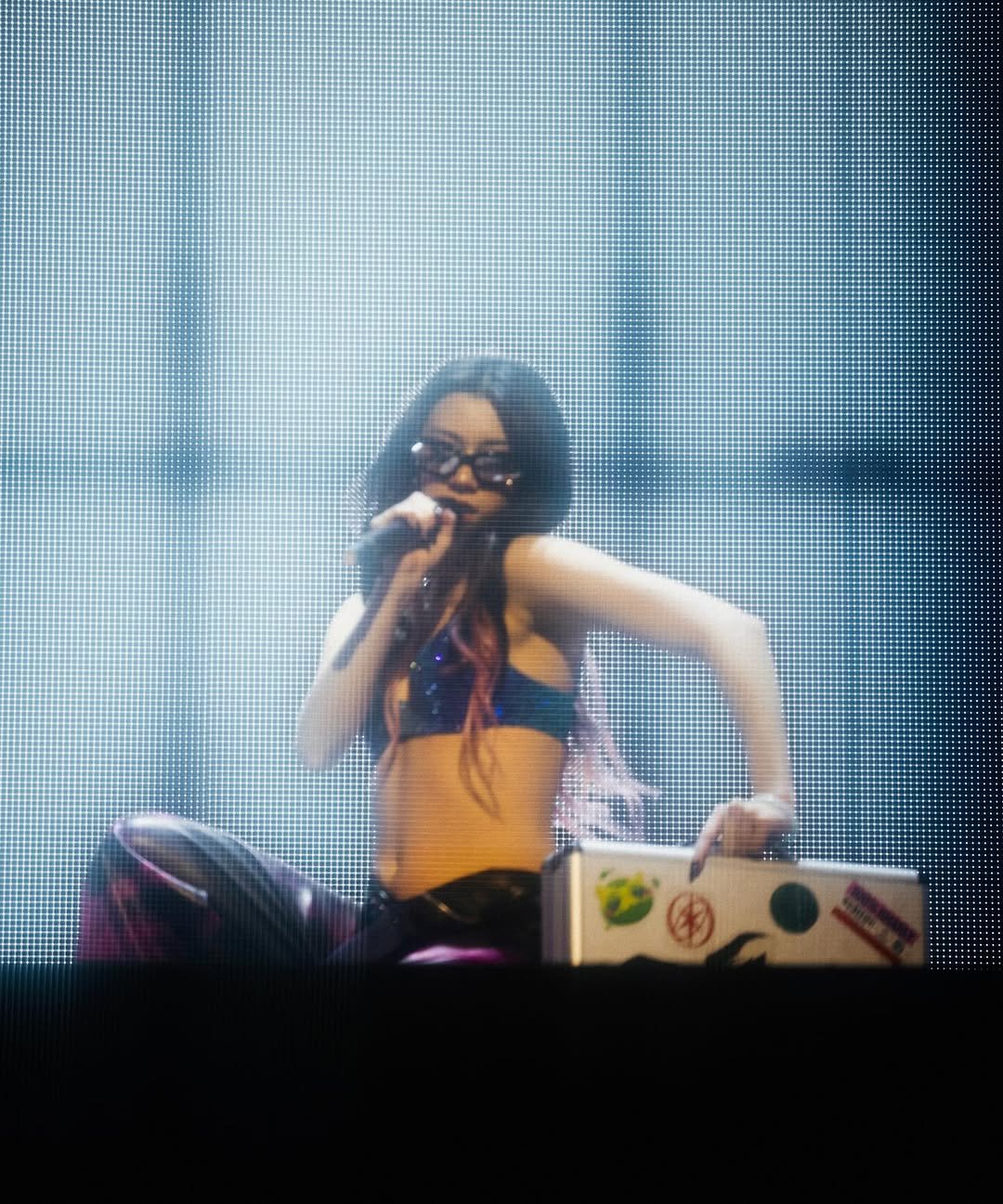 Photo by MEGAN MEIYOK SKIENDIEL on November 21, 2025. May be an image of microphone, fishnet stockings, concert and text.