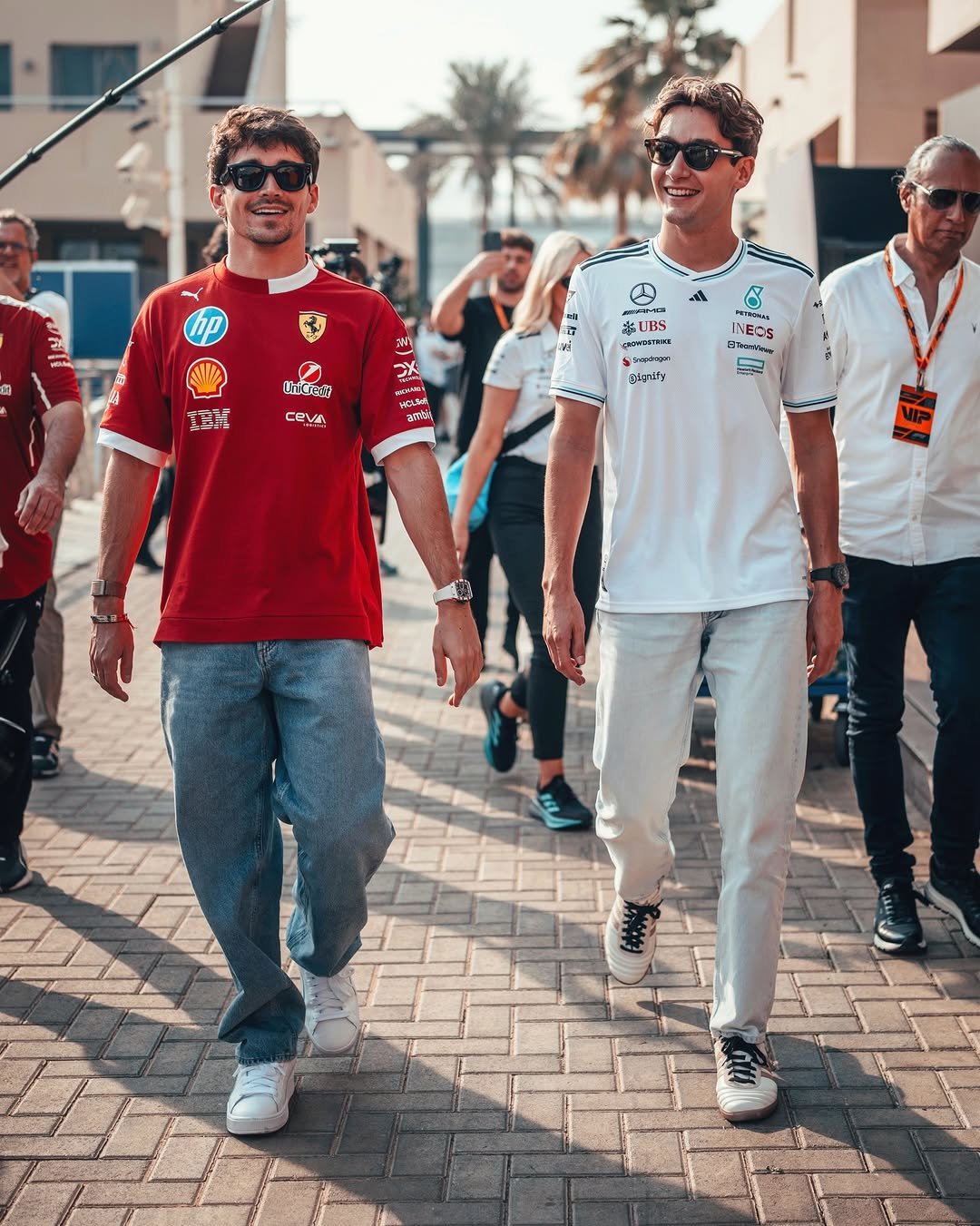 Charles Leclerc and George Russell walk in the Abu Dhabi paddock
