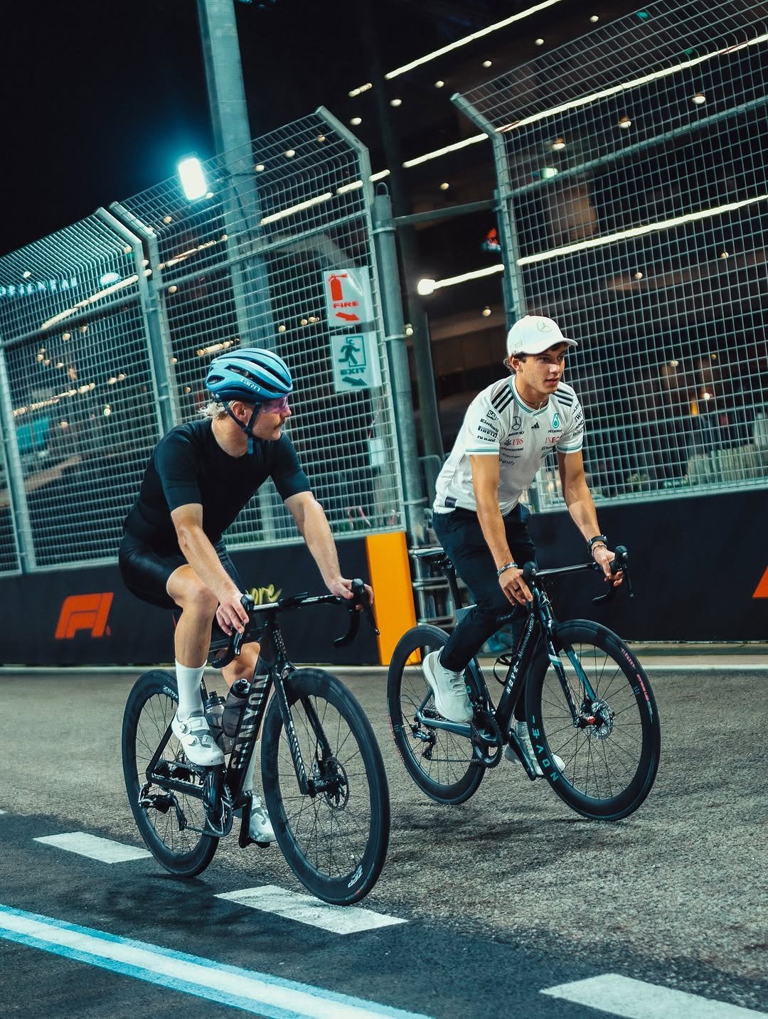 Photo shared by Mercedes-AMG Motorsport on October 02, 2025 tagging @mercedesamgf1, @mercedesamg, @valtteribottas, @f1, @mercedesbenzsg, and @kimi.antonelli. May be an image of 2 people, bicycle, tire, road and text.