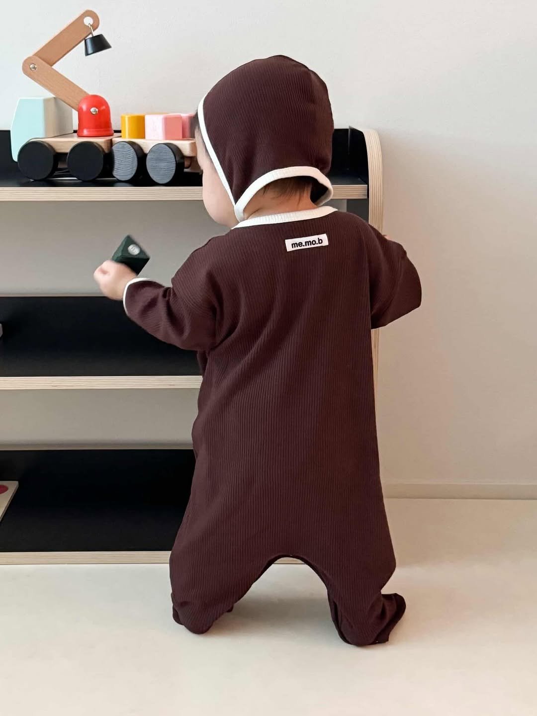 Photo by 메르모던(me.mo.b) on December 25, 2025. May be an image of baby, jumpsuit, baby shoes and text that says 'me me.mo.b mo.b'.