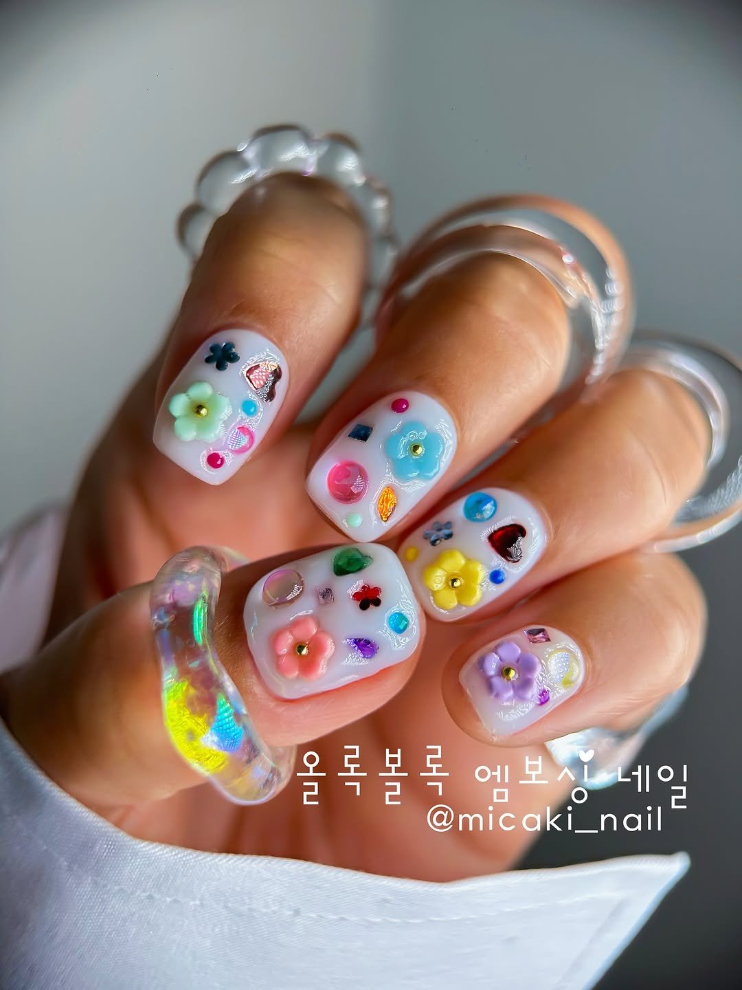 Photo shared by Mica Nail     Kakao Id*~micaki on July 20, 2025 tagging @gak_san, @artlee_jy, @micaki_nail, @dgel_korea, @nbeauty_nailn, @nailand17, @a.shining_moment, @by_muse_official, and @soyovy_official. May be an image of one or more people, fingernails and baby's-breath.