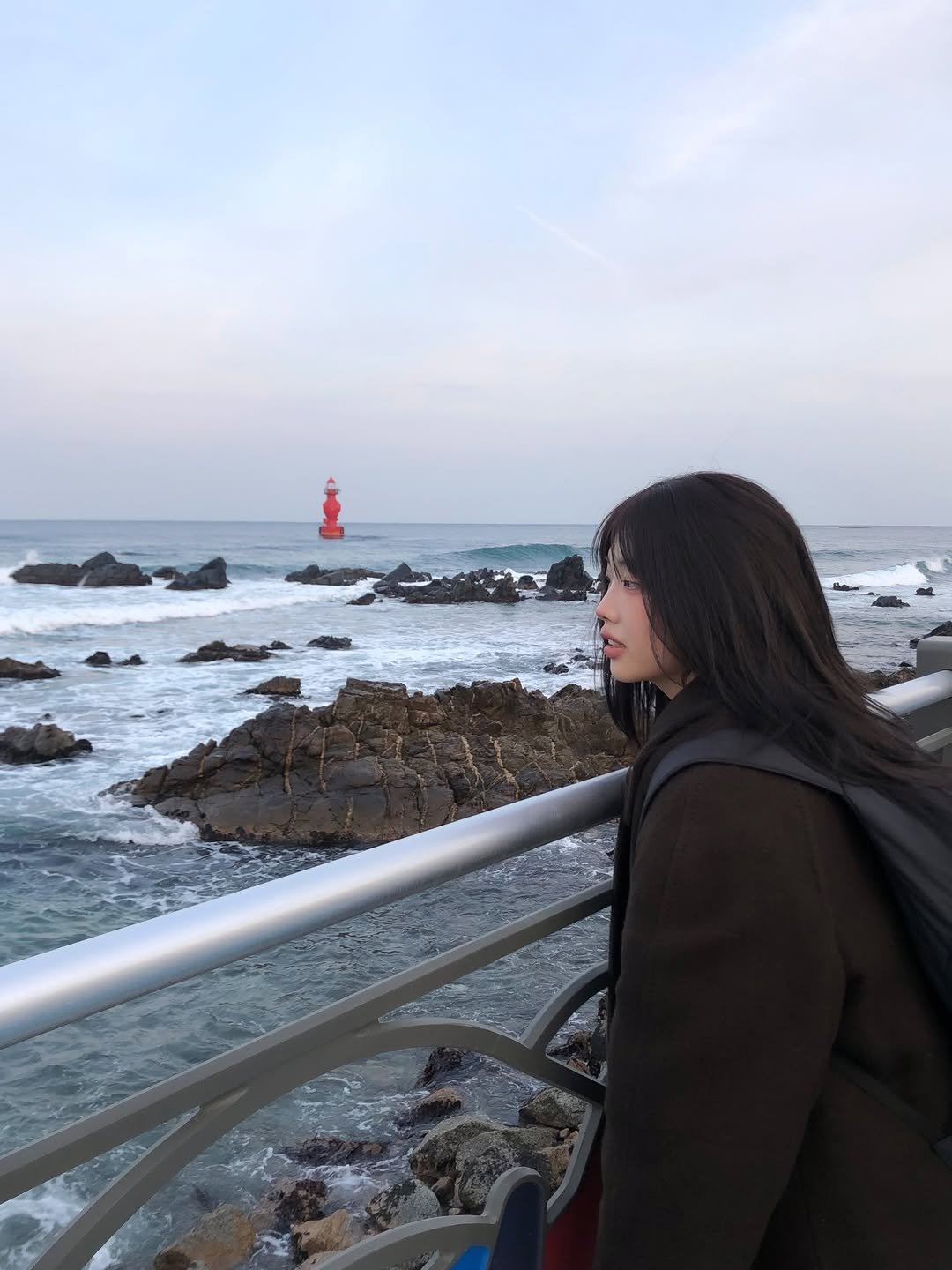 Photo by 이노마 on January 27, 2026. May be an image of duffle coat, ocean, coast, lighthouse and text.