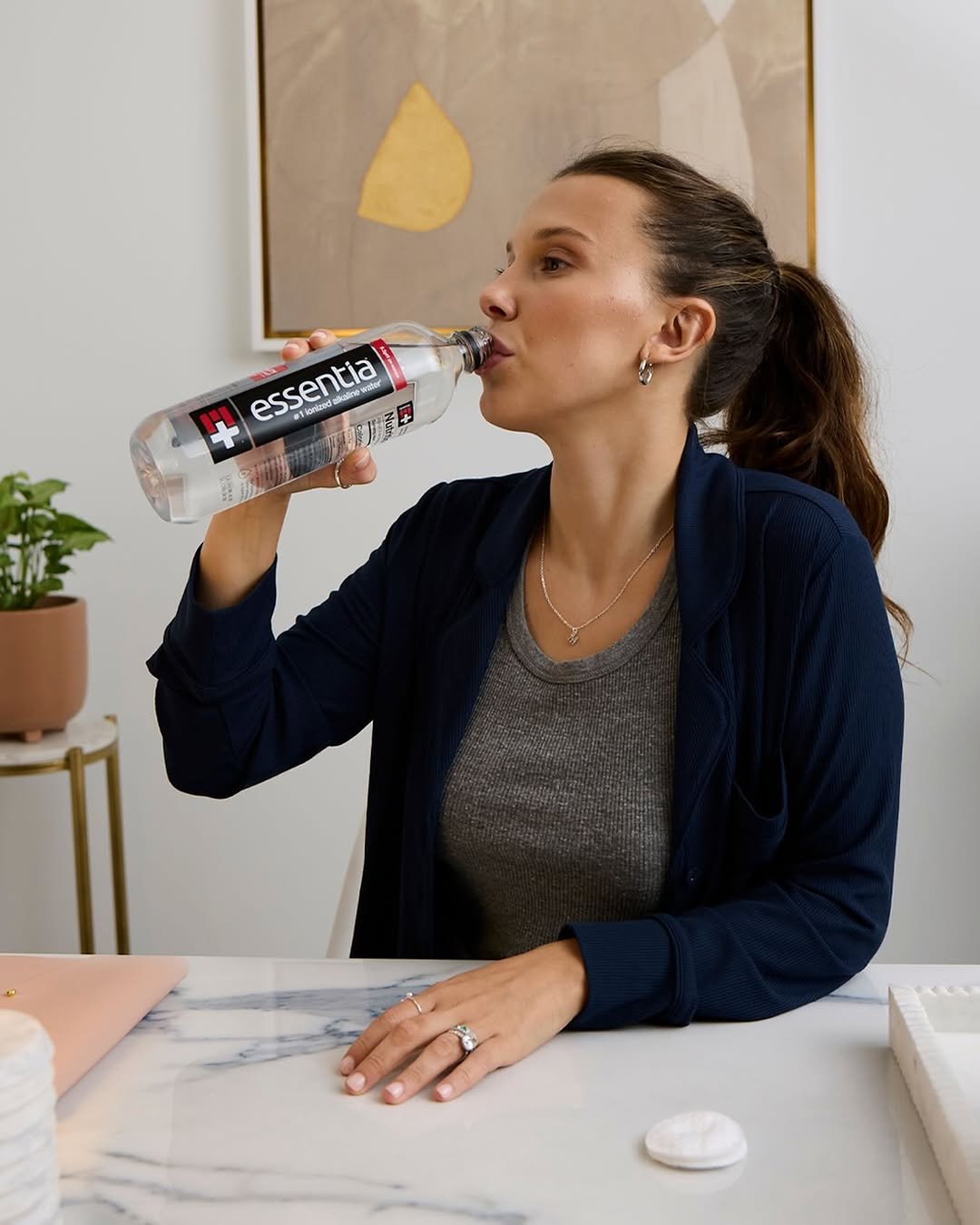 Photo shared by Millie Bobby Brown on February 06, 2026 tagging @essentiawater. May be an image of water bottle, bottle, jug, sparkling water, water filter, juice, body of water and text.