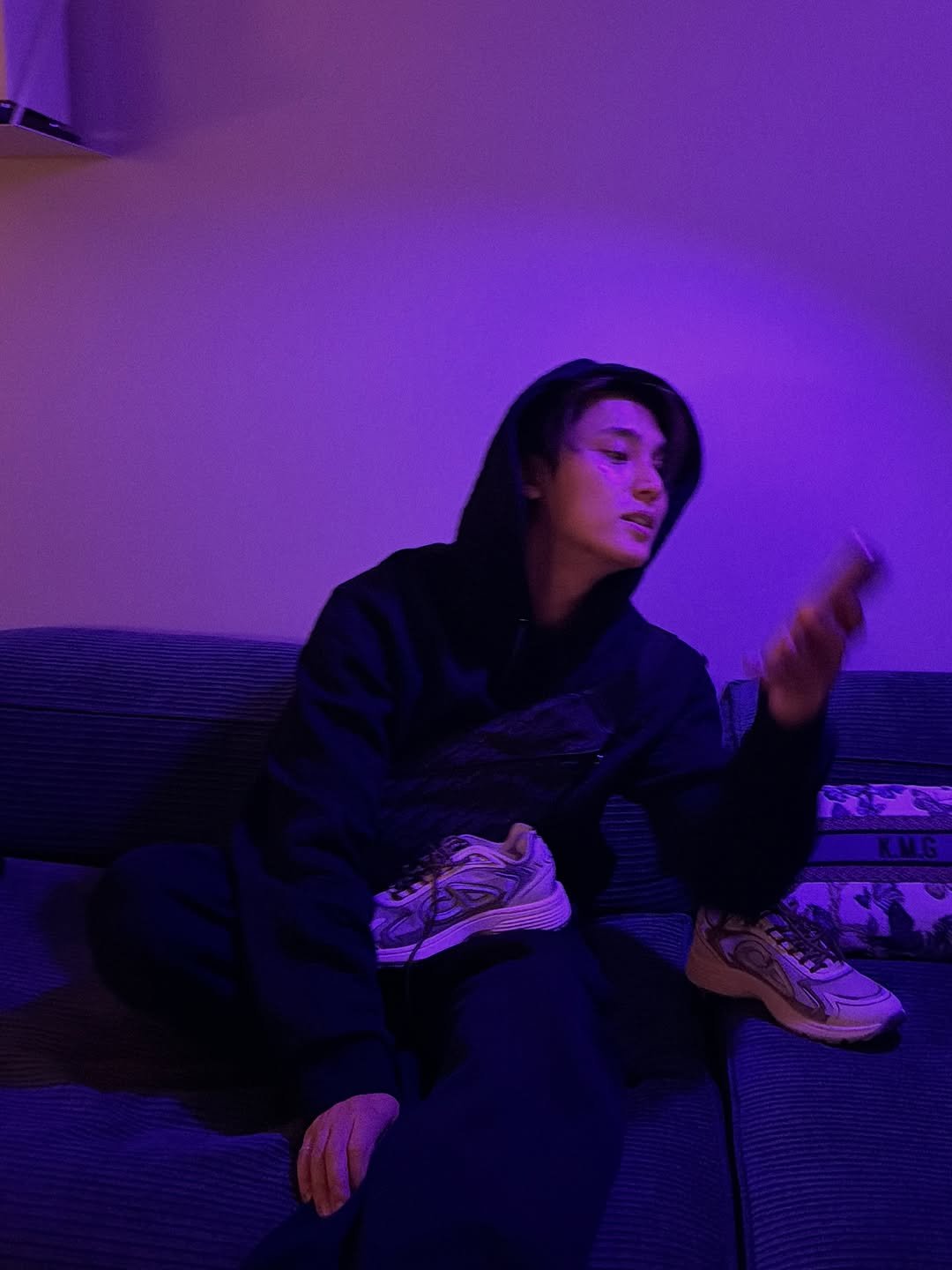 Photo shared by 김민규 on November 18, 2025 tagging @dior. May be an image of phone, cigarette, sweatpants and text.