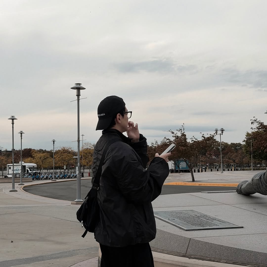 Photo by 김민규 on November 07, 2025. May be an image of one or more people, people standing, people smoking, duffle coat, overcoat, cigarette, parka, street and text.