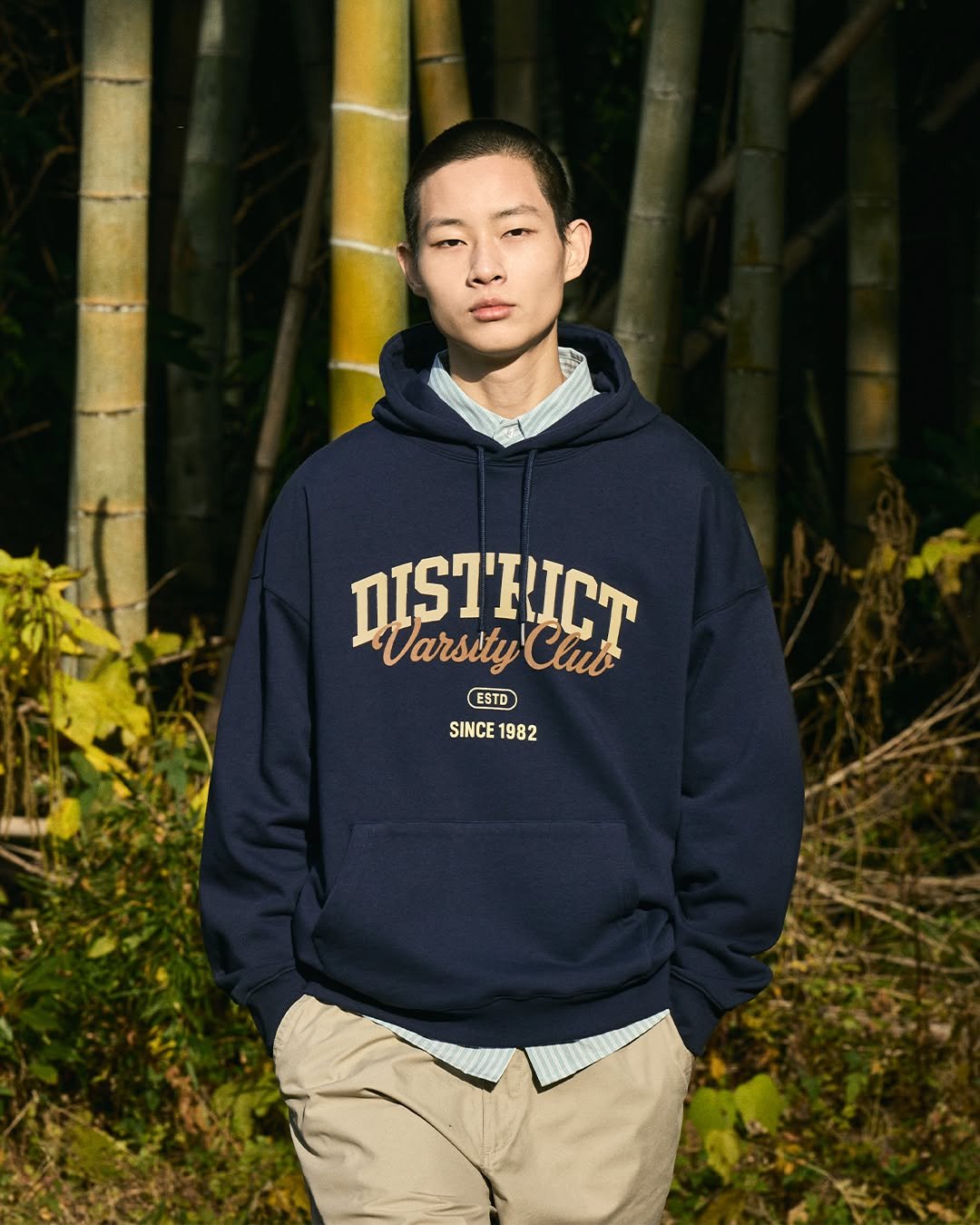 Photo by MINIMALPROJECT on February 13, 2026. May be an image of parka, sweatshirt, bamboo, outdoors and text that says 'DIST'RICT Varsity WarsityClut tyClub Club ESTO ESTD SINCE1982 SINCE 1982'.