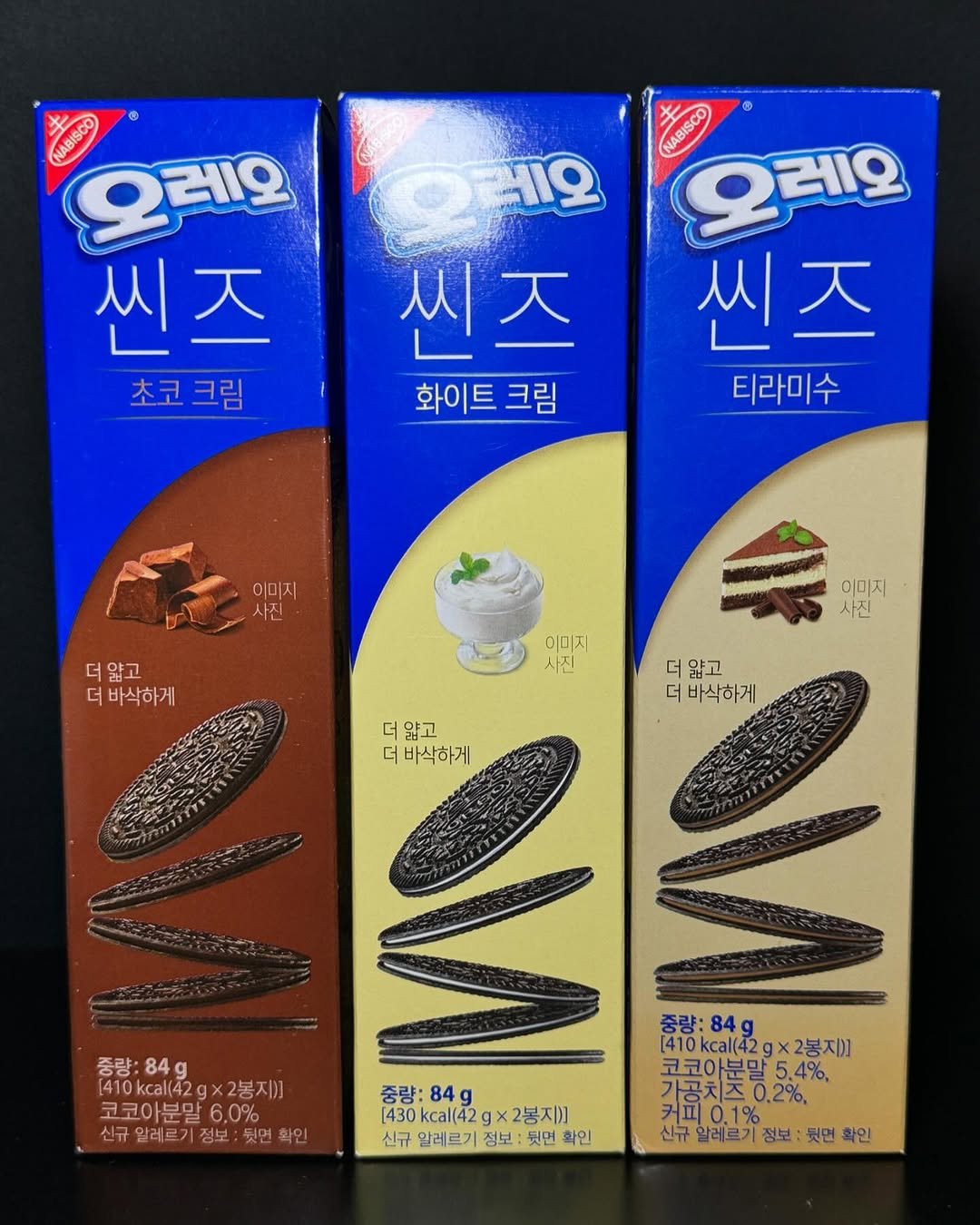 Photo by 전국 맛집 | 카페 | 여행 | 핫플 소개 on July 24, 2025. May be an image of cookie, wafer and text that says 'NABISCO 오레오 2레오 씬즈 초코크림 세오 씬즈 天 씨 화이트 크림 NABISCO 오레오 씬즈 티라미수 이미지 사진 더앓고 더 더바삭하게 이미지 사진 이미지 사진 더 얇고 더 바삭하게 더 얇고 더 바삭하게 중량: 84g [410kcal(42gx2봉지] x2봉지)] 코코아분말 6.0% 알레르기정보: 신규알레르기잠보:뒷면확인 뒷면 확인 중량: 84g [430 430kcal(42 kcal(42 gx2봉지)] [430kcal(42g×2봉지)] X 신규 알레르기 정보 뭣면 확인 중량:84 84g [410kcal(42g [410kcal(42gx2봉지] ×2봉지)] 코코아분말 가공치즈0.2% 코코아분말5.4% 4%, 신규 알레르기 정보: 뭣면 확인'.