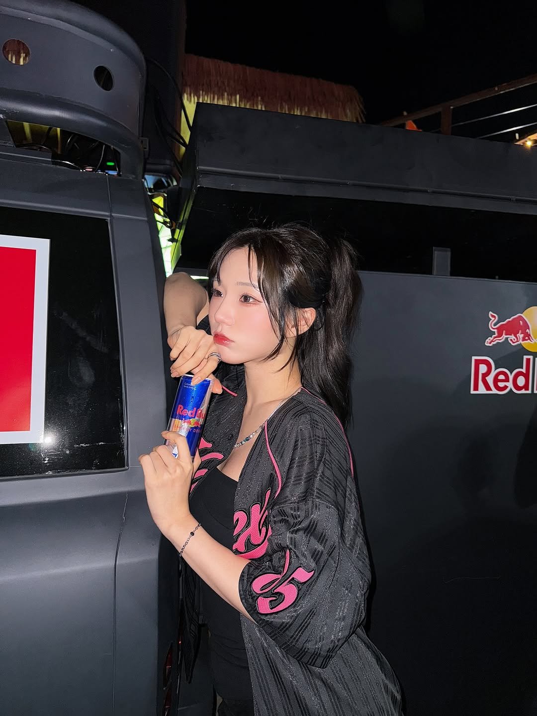 Photo shared by 미우 MIU on August 10, 2025 tagging @redbullkr. May be an image of 1 person, hair, dress, bus, top and text.