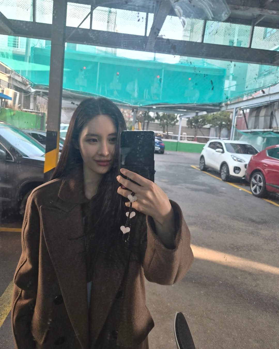 Photo by SUNMI on February 23, 2026. May be a selfie of one or more people, hair, duffle coat, overcoat, turtleneck, parka, jacket, mirror and text.
