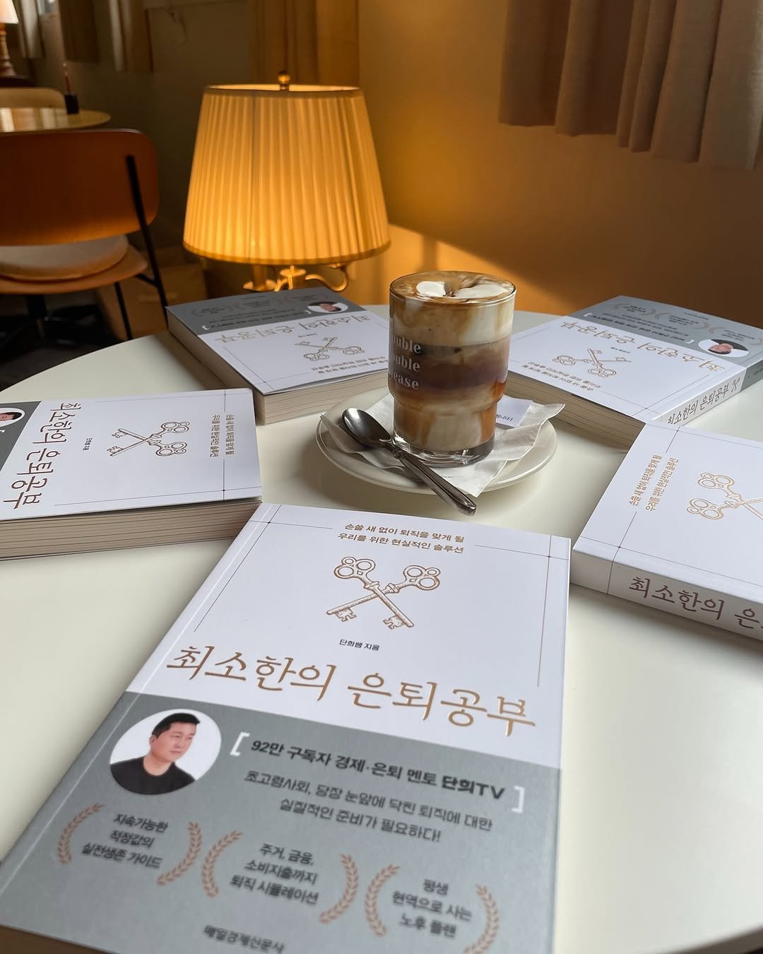 Photo by 매경출판 on October 01, 2025. May be an image of 1 person, coffee cup, book and text.