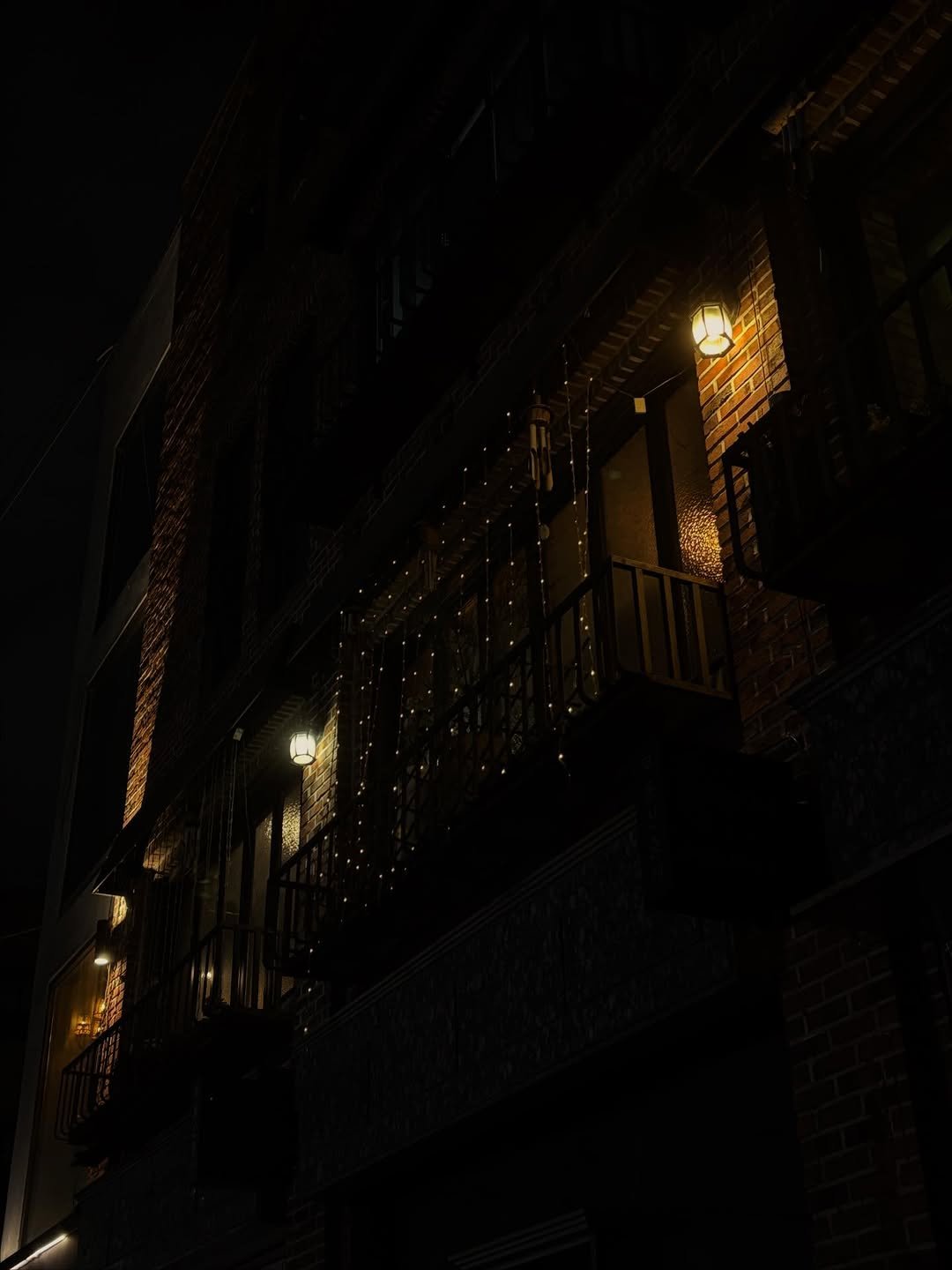Photo by Hyebin Kim on November 22, 2025. May be an image of fire escape, lighting, lantern, lightbulb, night, lamppost, buildings and text.