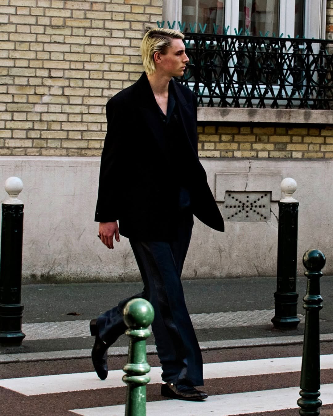 Photo by MMIC (엠엠아이씨) on April 19, 2026. May be an image of one or more people, people smoking, overcoat, cigarette, street, lamppost and text.