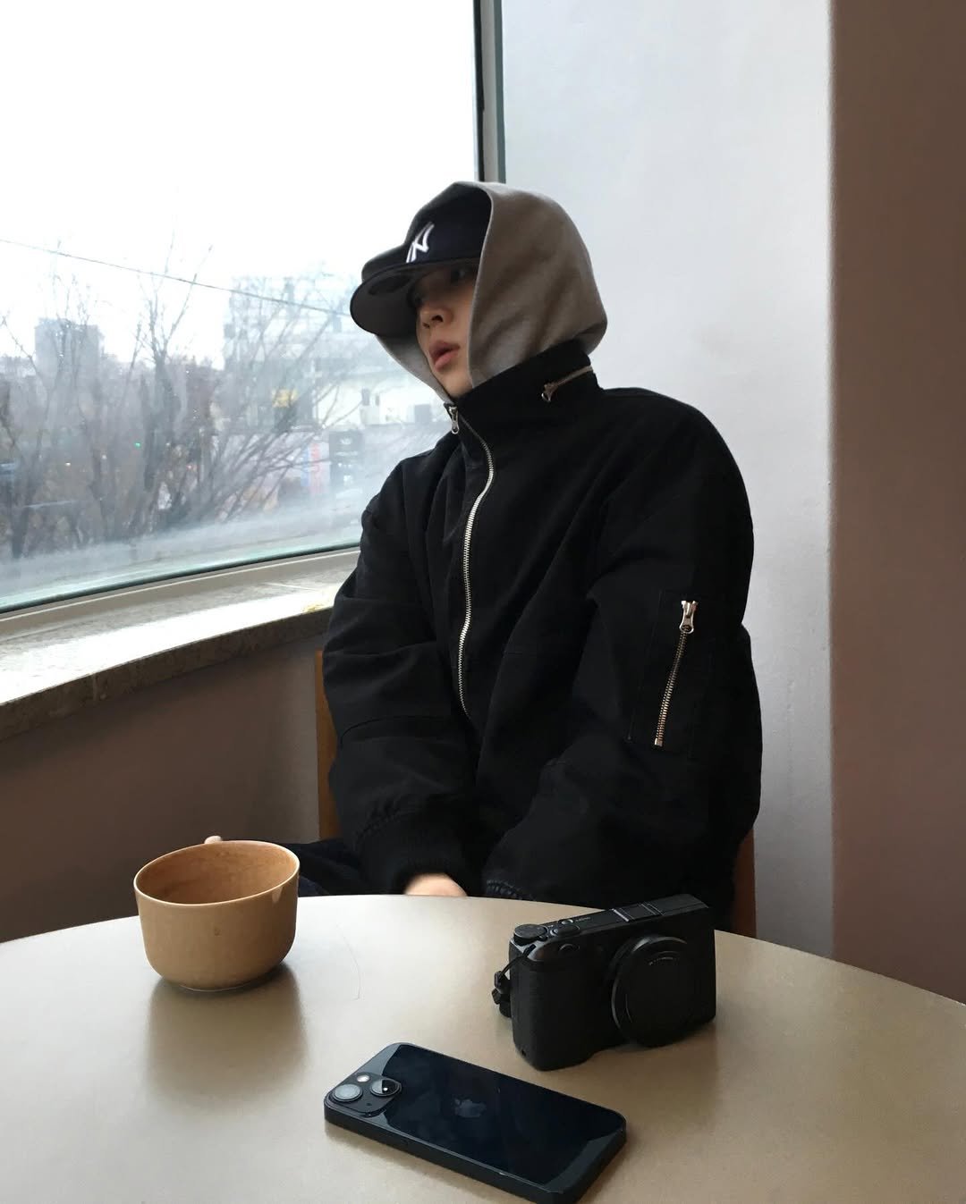 Photo by 민 서 on March 02, 2026. May be an image of phone, hat, duffle coat, parka, face mask and text.