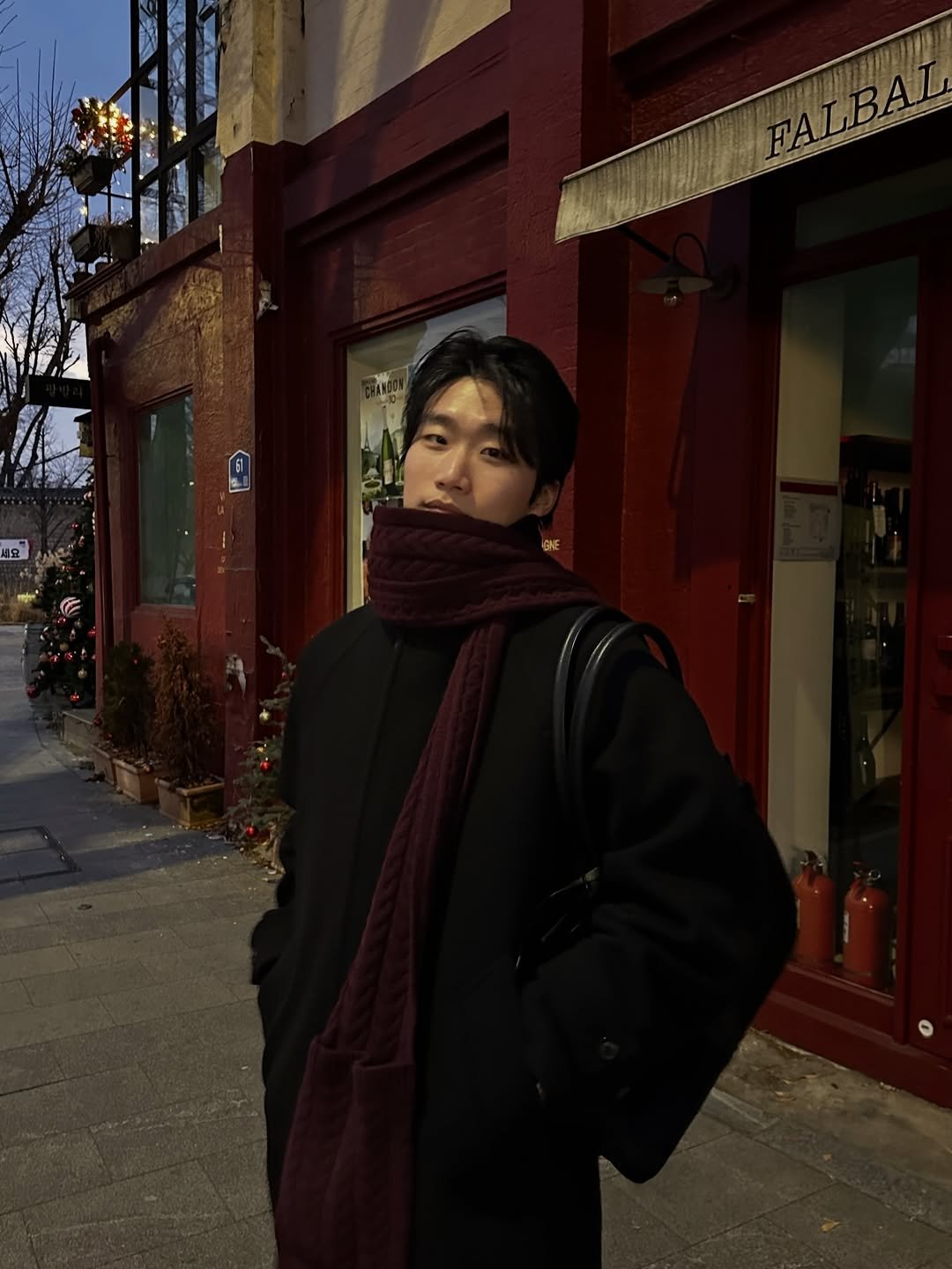 Photo shared by 라오라오 on December 29, 2025 tagging @afterpray_official. May be an image of duffle coat, overcoat, scarf, parka, turtleneck, street and text.