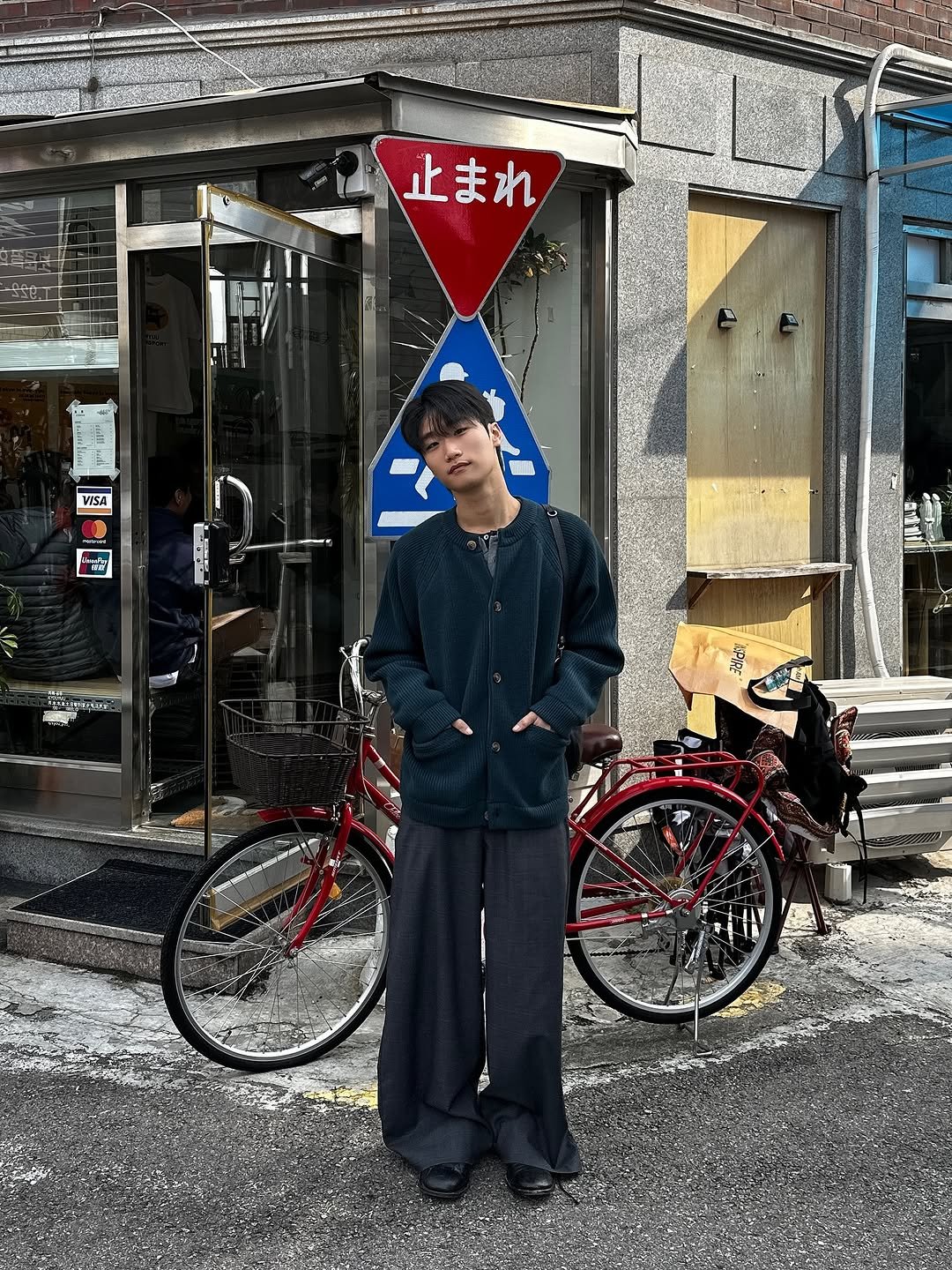Photo shared by 라오라오 on November 02, 2025 tagging @horlisun, and @helet.official. May be an image of bicycle, duffle coat, overcoat, scooter, tire, umbrella, street and text.
