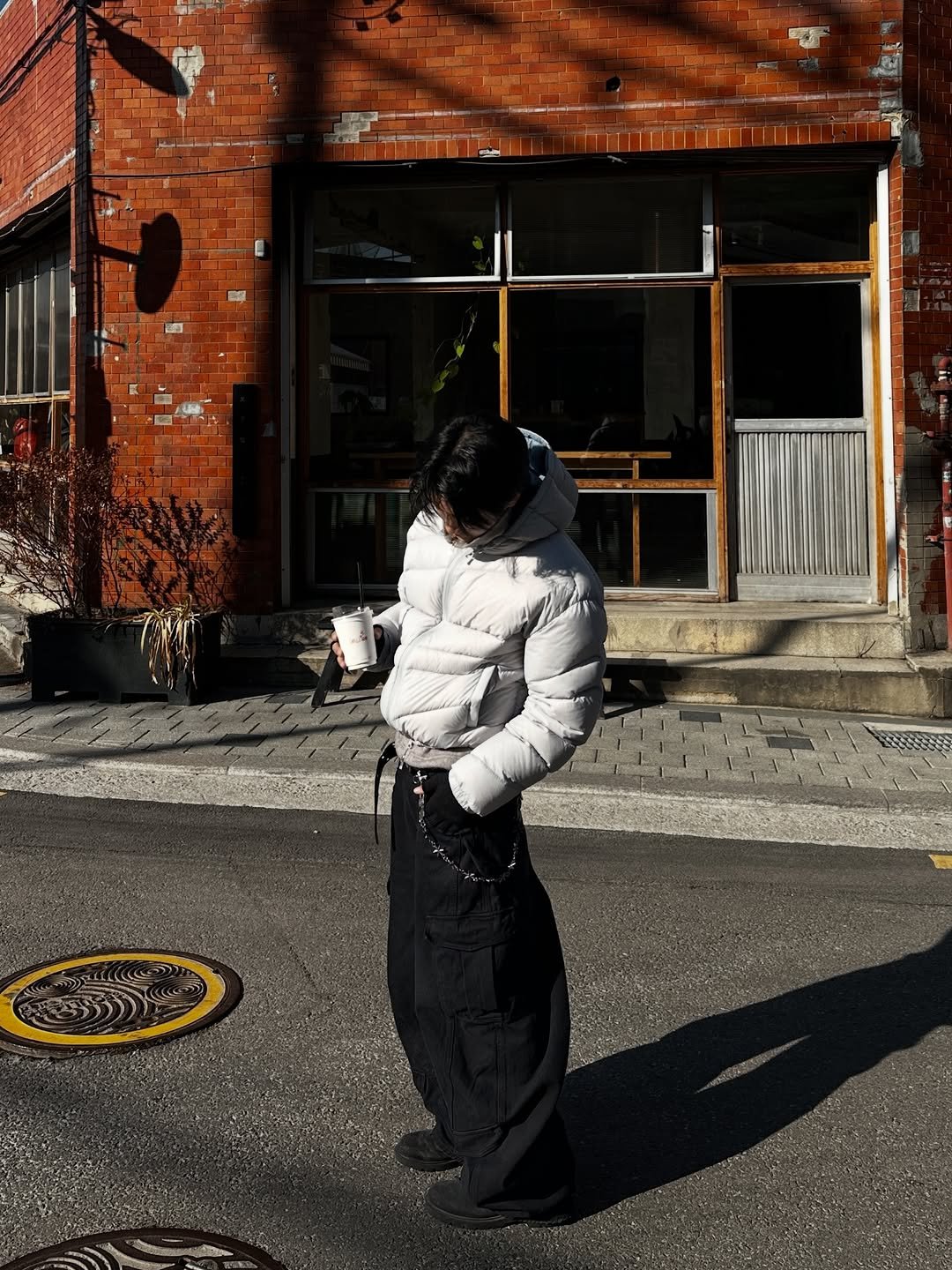 Photo shared by 라오라오 on December 18, 2025 tagging @learve_official, @mimthewardrobe, and @koinseoul. May be an image of standing, goosedown coat, duffle coat, overcoat, face mask, parka, snowsuit, street, brick wall and text.