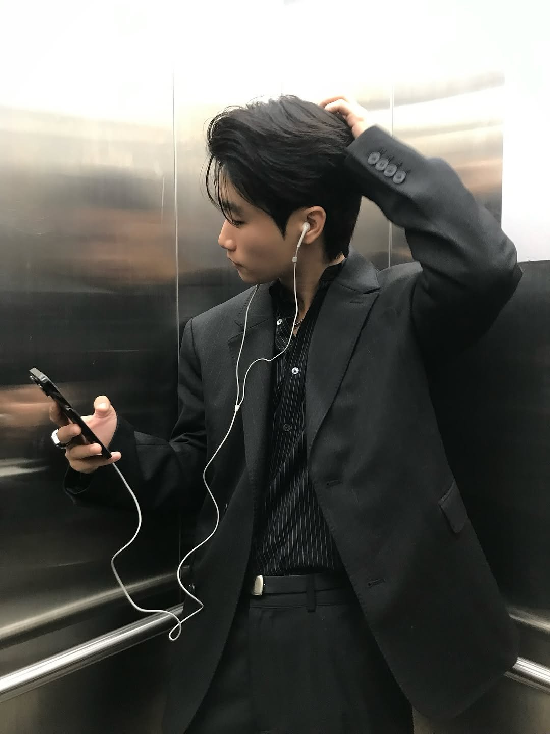 Photo by 라오라오 on November 05, 2025. May be an image of phone, bolo tie, suit, blazer and text.