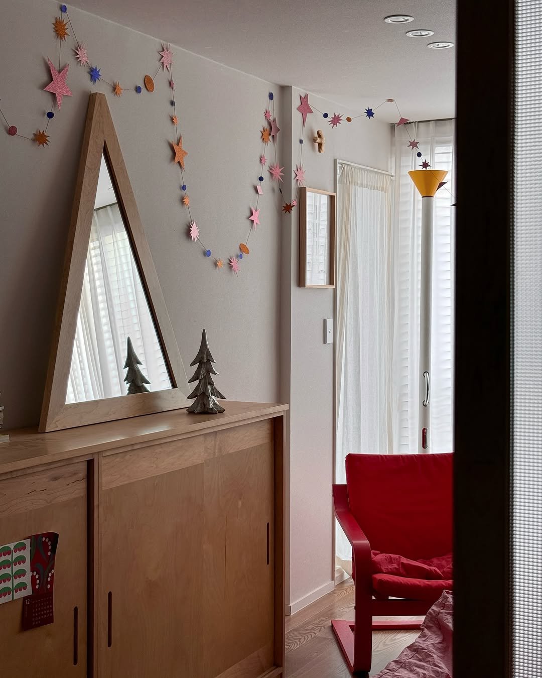 Photo shared by 아이와 고양이와 부부가 사는 작은 집 on December 21, 2025 tagging @cocon.kr, @lenebjerredesign, @artemide_lighting, @nordicnest.kr, @chapter1_official, @todayhouse, @ikea, @ikeakr, @mopo.intheroom, @thisismine_woodworking, and @colletf_official. May be an image of wind chime, tinsel, curtains, window and text.