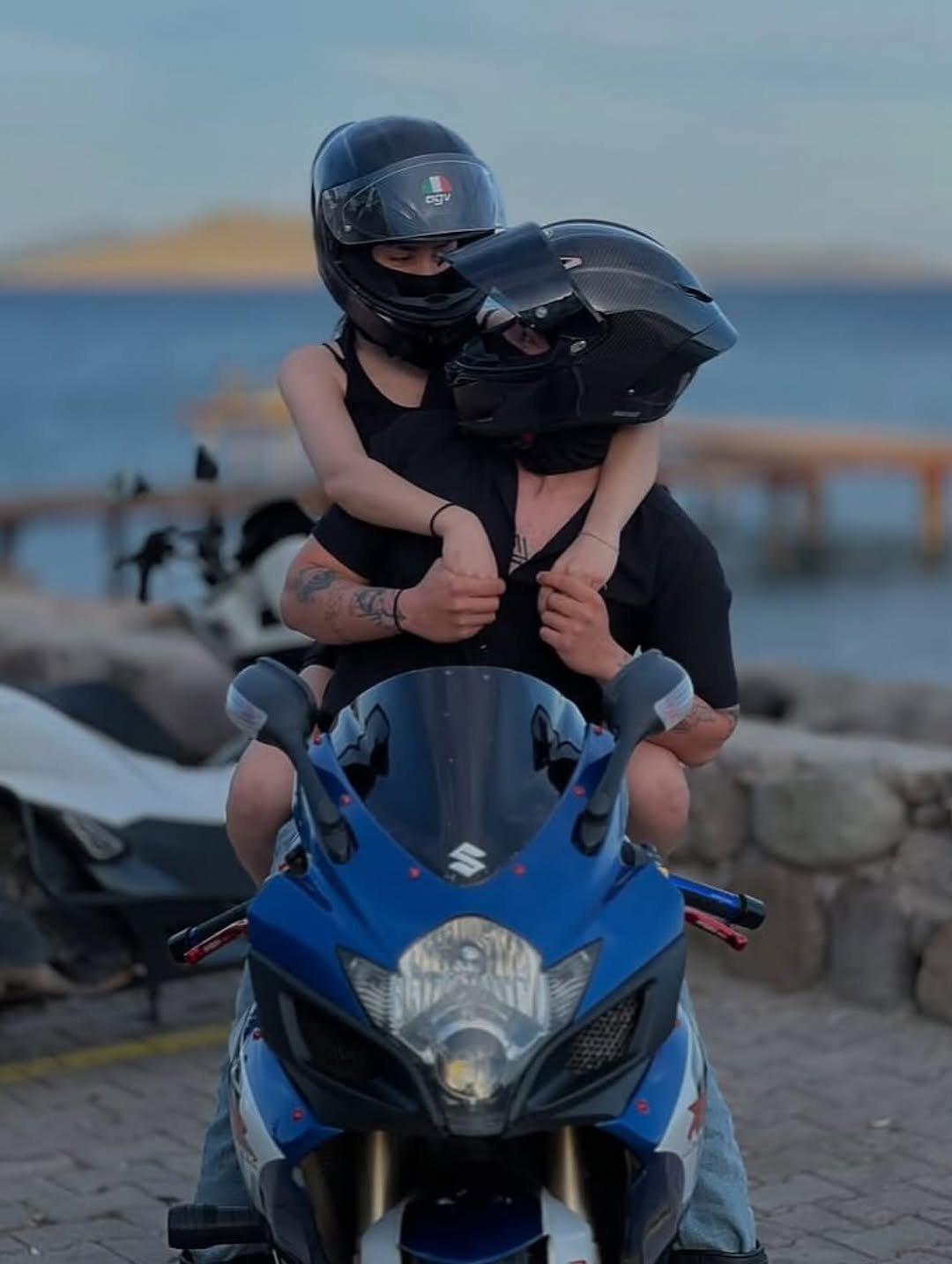 Photo by ❥ on August 06, 2025. May be an image of 1 person, people kissing, motorcycle, helmet, scooter and text.