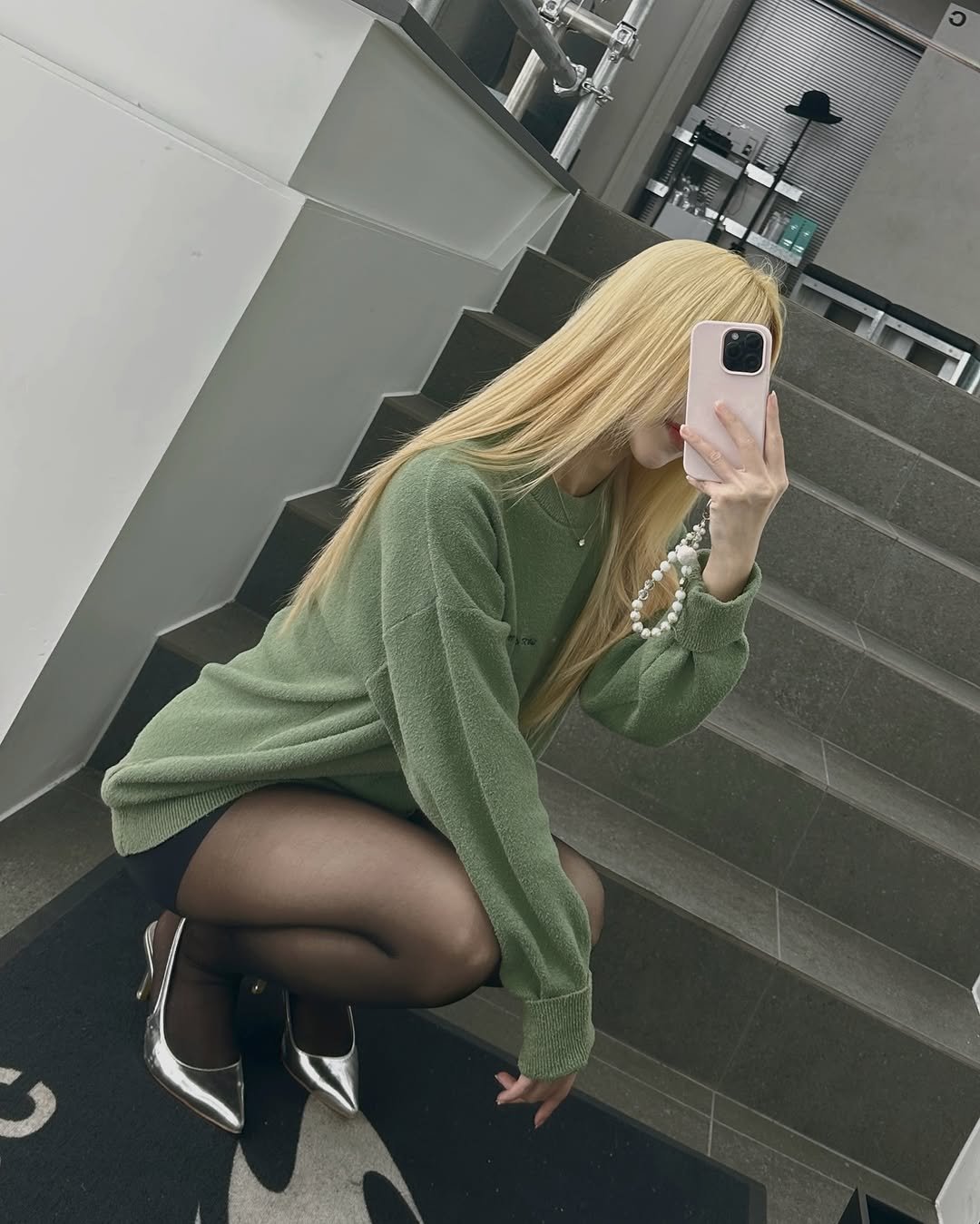 Photo shared by Kim Mumu on October 05, 2025 tagging @moc_jk. May be a selfie of 1 person, makeup, phone, tights, sweater, miniskirt, fishnet stockings and text.