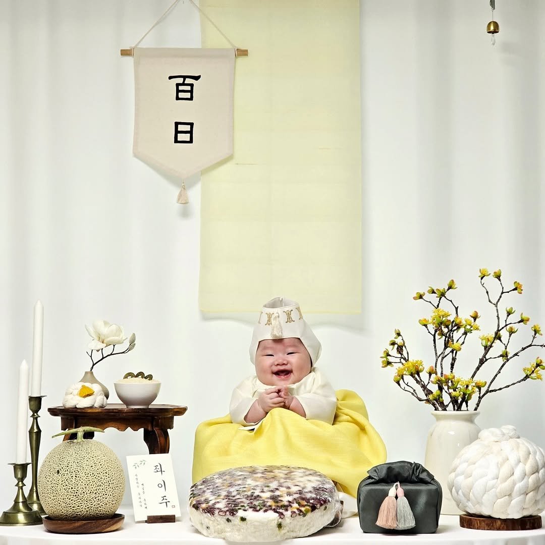Photo shared by @ming_u91 on September 14, 2025 tagging @musclefit_jjoah. May be an image of 1 person, baby, placemat, baby bed, banner and text that says '【百 日 日 百 እን 최 ને 주'.